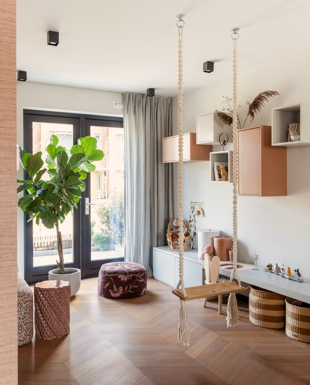 Schommel CreaMePassion, bank links HKliving, keramische kruk Floris Wubben, gordijnen Kwantum, zwarte plafondspots Qazqa, lage wandbank eigen ontwerp, hangkasten Ikea, geverfd in kleuren French Grey Mid van Little Greene en D8.24.44 van Sikkens, gebloemde poef Sissy-Boy, stoeltje Petite Amélie, manden en opruimdozen Oyoy. Overig onbekend. vtwonen 09-2022 | Fotografie Margriet Hoekstra