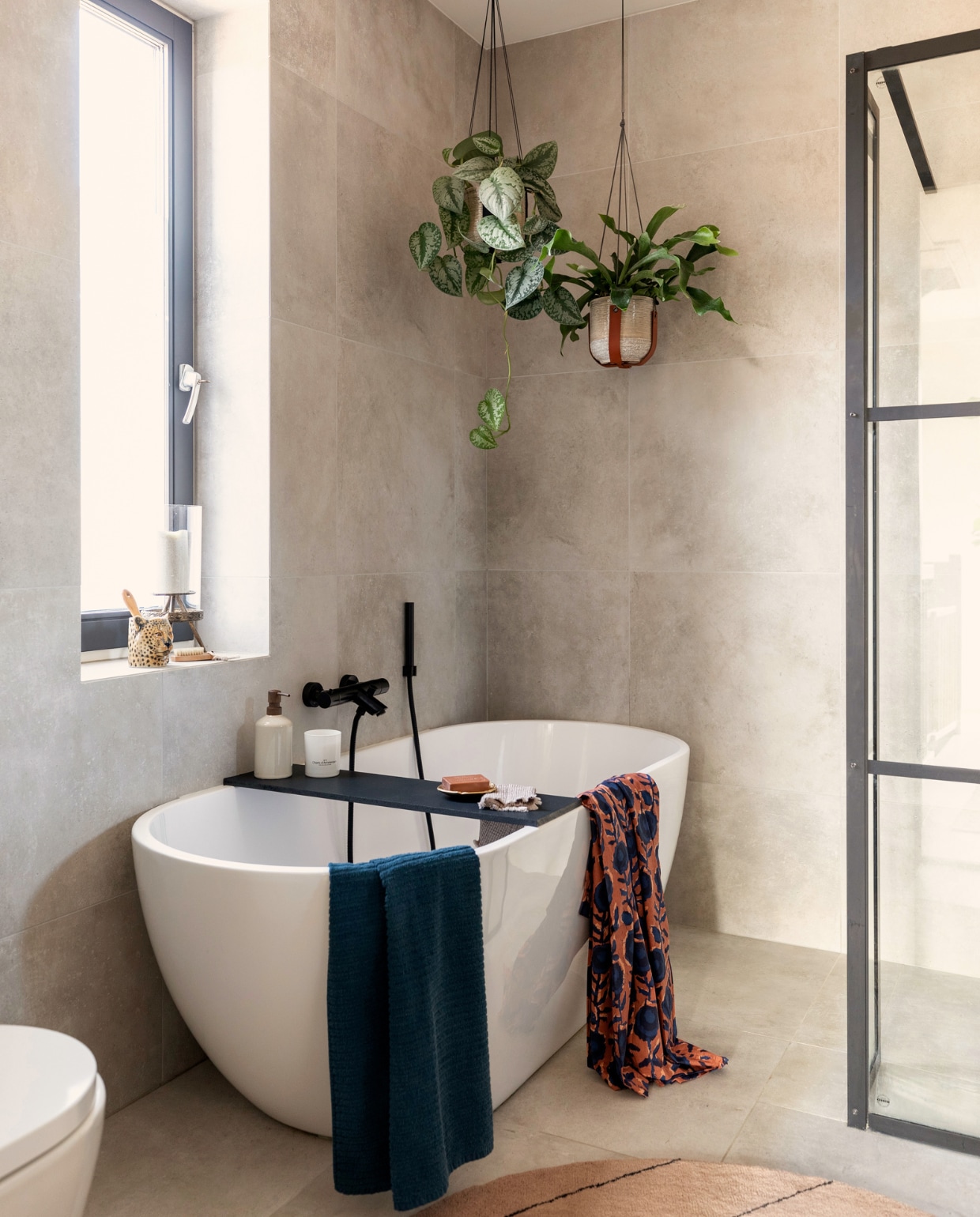 Bad, douchewand, kranen Sanitairkamer, tegels Tegelsinhuis, plantenhangers Madam Stoltz, zeeppomp en blauwe handdoek H&amp;M Home, luipaard Anna &amp; Nina, windlicht Intratuin. vtwonen 09-2022 | Fotografie Margriet Hoekstra