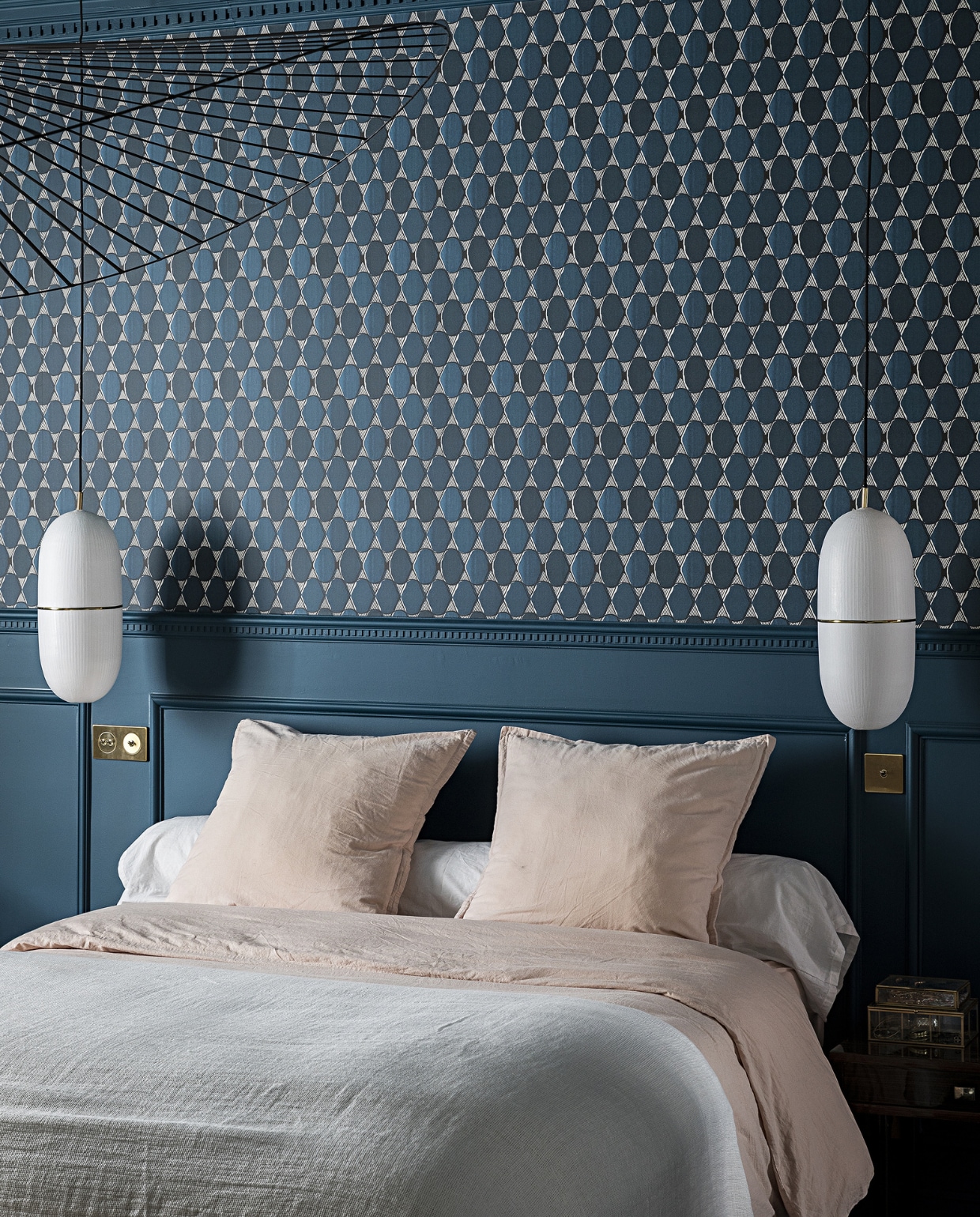 Verfkleur Bleu Minuit van Maison Sarah Lavoine (via ressource-peintures.com). Behang L’Illusion Nobilis. , Zwarte hanglamp Vertigo Petite Friture. Witte hanglampen Céline Wright. Goudkleurige lichtschakelaars Also &amp; Co. Beddengoed onbekend. NEE | vtwonen special binnenkijken 2022-3 | Productie AC Scoffoni | Styling Marie-Maud Levron | Fotografie Yann Deret | Tekstbewerking Renate Dahlmans