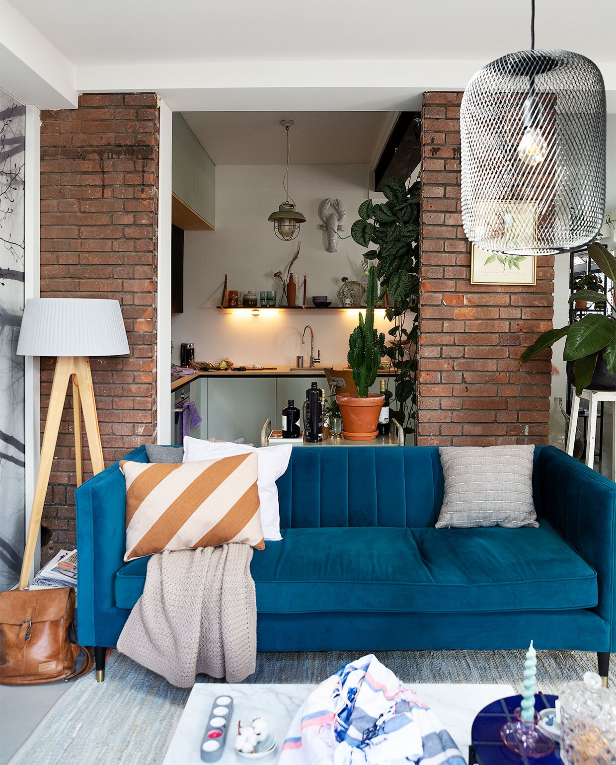 Blauwe bank Made, leren tas Leather Junky, gestreept kussen Sissy-Boy, lila kussen H&amp;M Home, grijs kussen Hay, grijs gestreept kussen Leen Bakker, gehaakte sprei zelfgemaakt. Staande lamp Made. Trolley achter bank, hoge witte kruk Van Dijk &amp; Ko, vaas Bloomon. Schilderij kringloop, hanglamp Karwei, marmeren salontafel Zuiver, ronde salontafel, hammandoek Sissy-Boy, waxinehouder Seen Design, schaaltje met bolletje katoen kringloop, roze kandelaar Hay, glazen pot vintage uit Frankrijk. NEE  | vtwonen binnenkijken special 2021 | Fotografie Jansje Klazinga | Styling Roy Seen