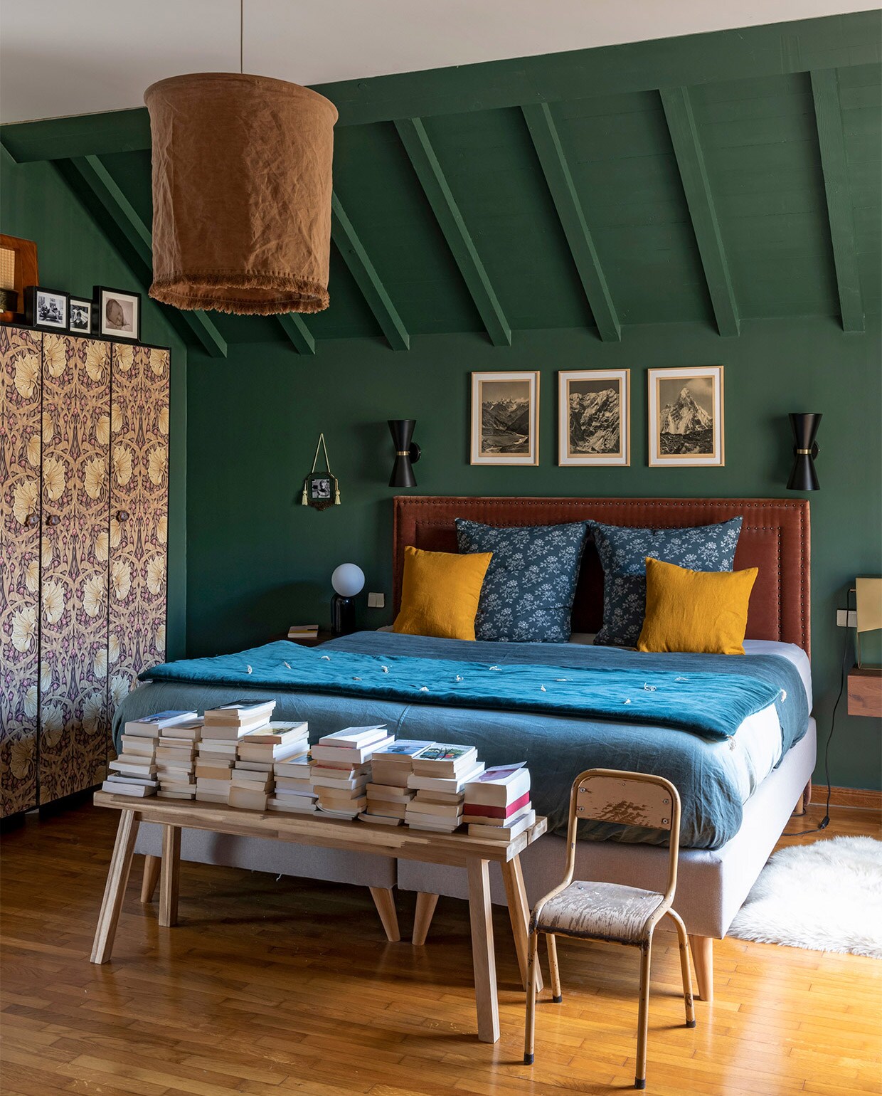 Muurverf groen zelf gemengd, prints bergen vintage, kledingkast vintage met William Morris behang, wandlampen Made, hoofdbord en nachtkastjes AMPM La Redoute, hanglamp Madam Stoltz, beddengoed Lab Boutique, kussens Camomile London, sprei Caravane, vloerkleed Fab Design, bankje Ikea, overig vintage. vtwonen binnenkijken special 2021 | productie A&amp;J | fotografie Julien Fernandez