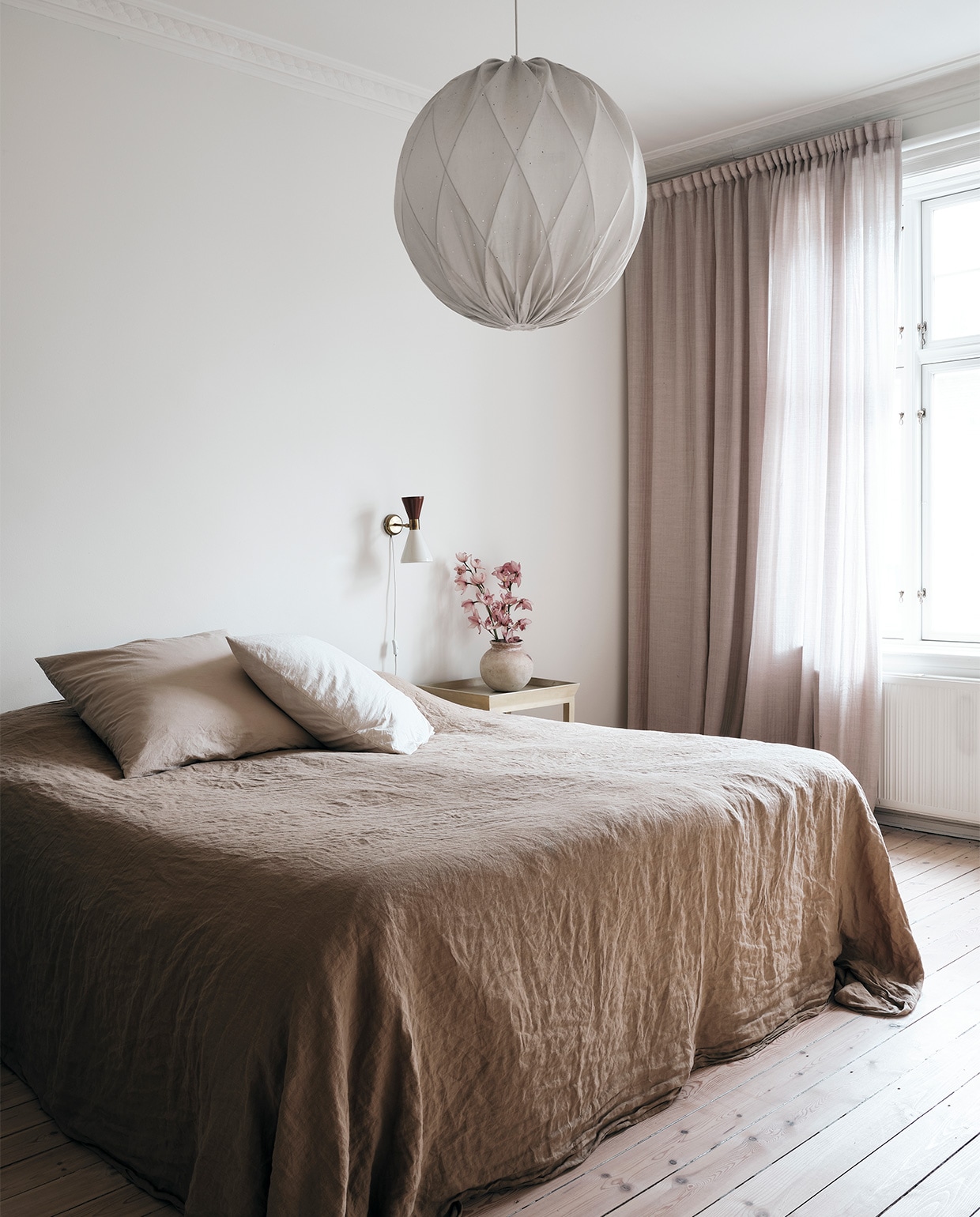 Gordijnen Astrid Textiles, bedlinnen Merci Paris, vintage bedlamp uit antiekwinkel in Milaan, Franse antieke tafel cadeau gekregen. Hanglamp Pia van Gärsnäs. NEE | vtwonen binnenkijken special 2021 | productie Living Inside | fotografie Christoffer Regild
