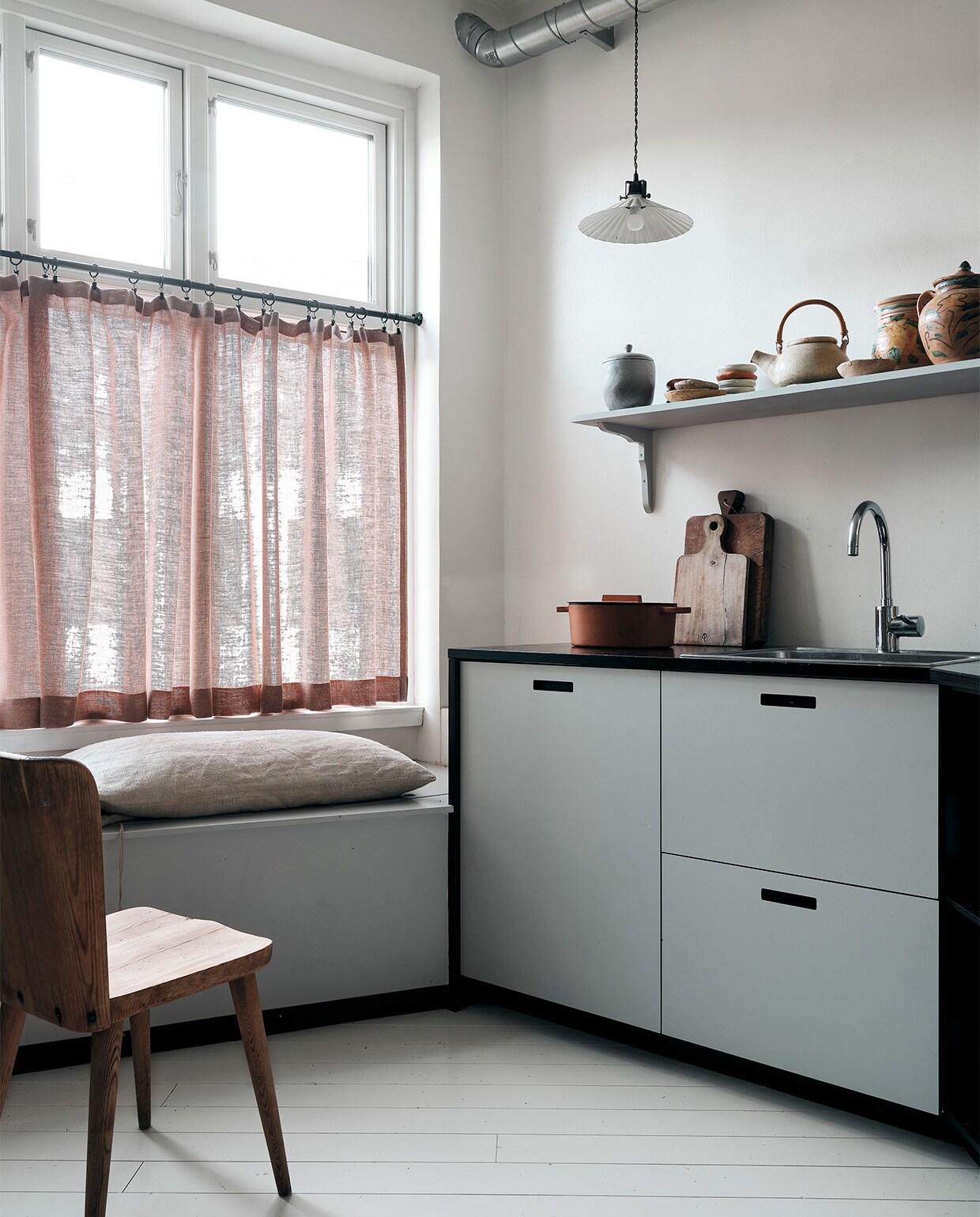 Keuken op maat gemaakt in Kopenhagen. Vintage houten snijplanken en pan, gordijnen Astrid Textiles. Op een antieke plank keramiek uit Sicilië, handgemaakt door Ellen en vondsten van rommelmarkten. Vintage lampje, vintage stoel Gøran Malmvall. NEE | vtwonen binnenkijken special 2021 | productie Living Inside | fotografie Christoffer Regild