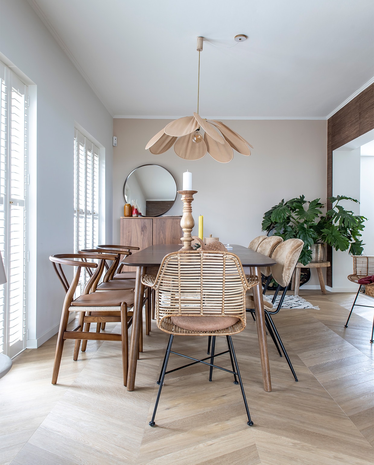 Muurkleur Flexa Gentle Umber. Behang Eijffinger Natural grasweefsel. Vloer Hongaarse punt pvc Therdex 6541. Houten stoelen Wishbone Chair, uitschuifbare tafel Sohome, gele kaars Sissy-Boy, kaarsenstandaard Loft Arnhem, rotan stoelen en drie stoelen rechts, rond kussen, kleed en plantentafel HKliving. Kast en spiegel Ikea Stockholm-lijn, vaasjes Zara home, lamp Archive Store. Shutters Veneta. vtwonen binnenkijken special 12-2021 | fotografie Henny van Belkom