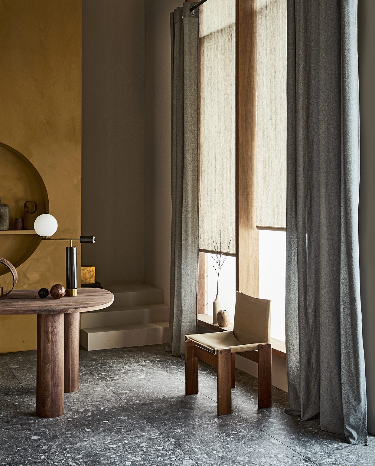 Gordijn Droplet, donkergrijs, lichtdoorlatend met ring, 270×140 cm (hxb) € 52,99. Rolgordijn Typhoon, lichtdoorlatend, 190×60/90/120/150/180/210 cm (hxb) vanaf € 45,29.M.m.v. karwei.nl (verf trap en achterwand Flax van vtwonen), vtwonen.nl (vloertegels Composite Multicolor van vtwonen), thomstudio.nl (walnotenhouten tafel), sitonvintage.com (stoel), neeflouis.nl (lamp), lauthentique.nl (muurverf lime paint oker 153), bloomingville.com (hoge vaas). Overig privébezit. JA vtwonen 07-2021  |  styling Cleo Scheulderman | fotografie Jeroen van der Spek