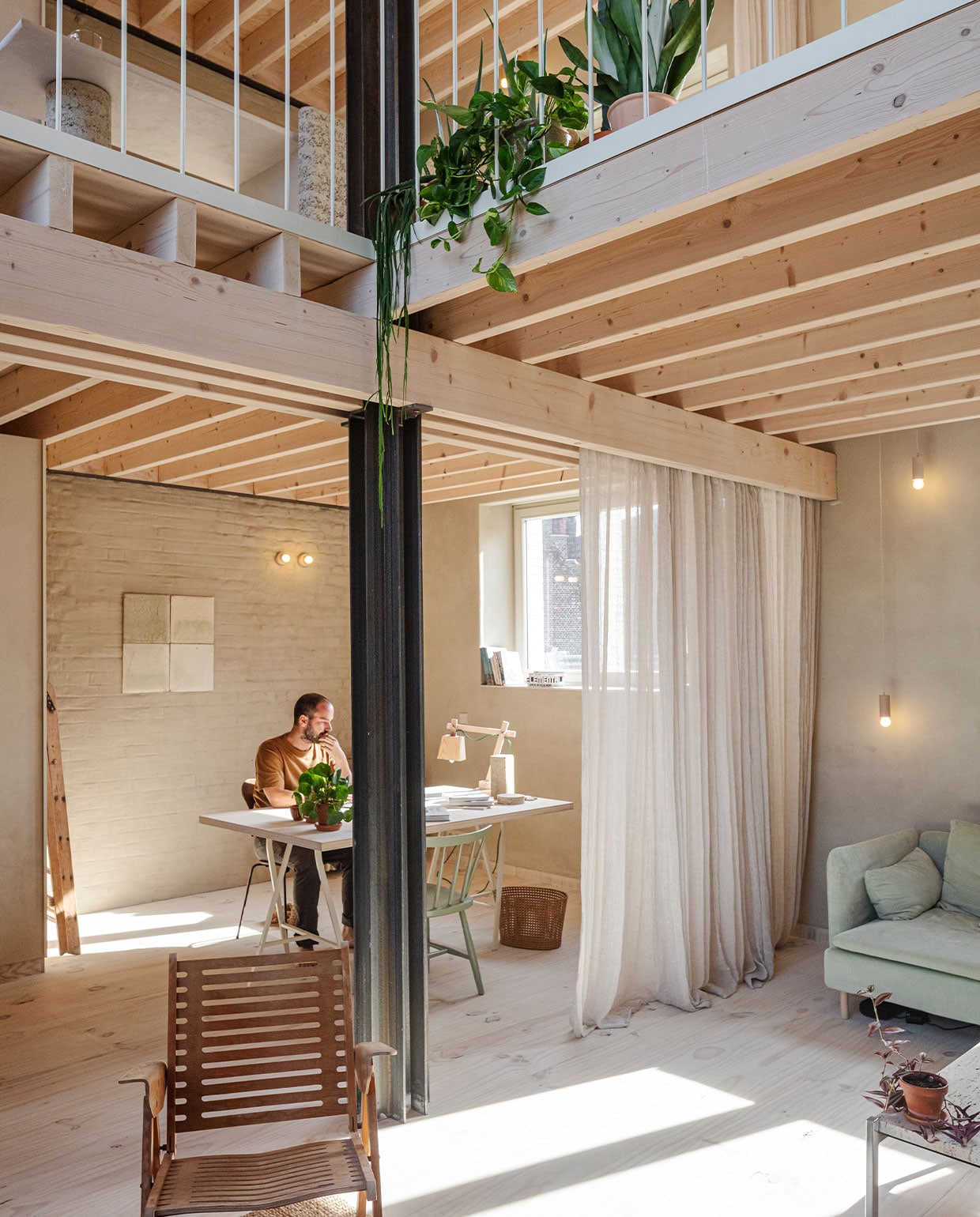 Bureau met multiplex blad op schragen van Ikea. Stoelen, prullenbak en ladder gekregen van Hanne’s oma. Verlichting gemaakt door de vader van Nicolas. Bureaulamp Muuto. Aan muur proefstalen van leempleister met algen voor een project van BC Materials. Stoelen Niko Kralj. NEE | vtwonen 7-2022 | fotografie Tim Van de Velde | tekst Iris De Feijter | tekstbewerking Chris Muyres