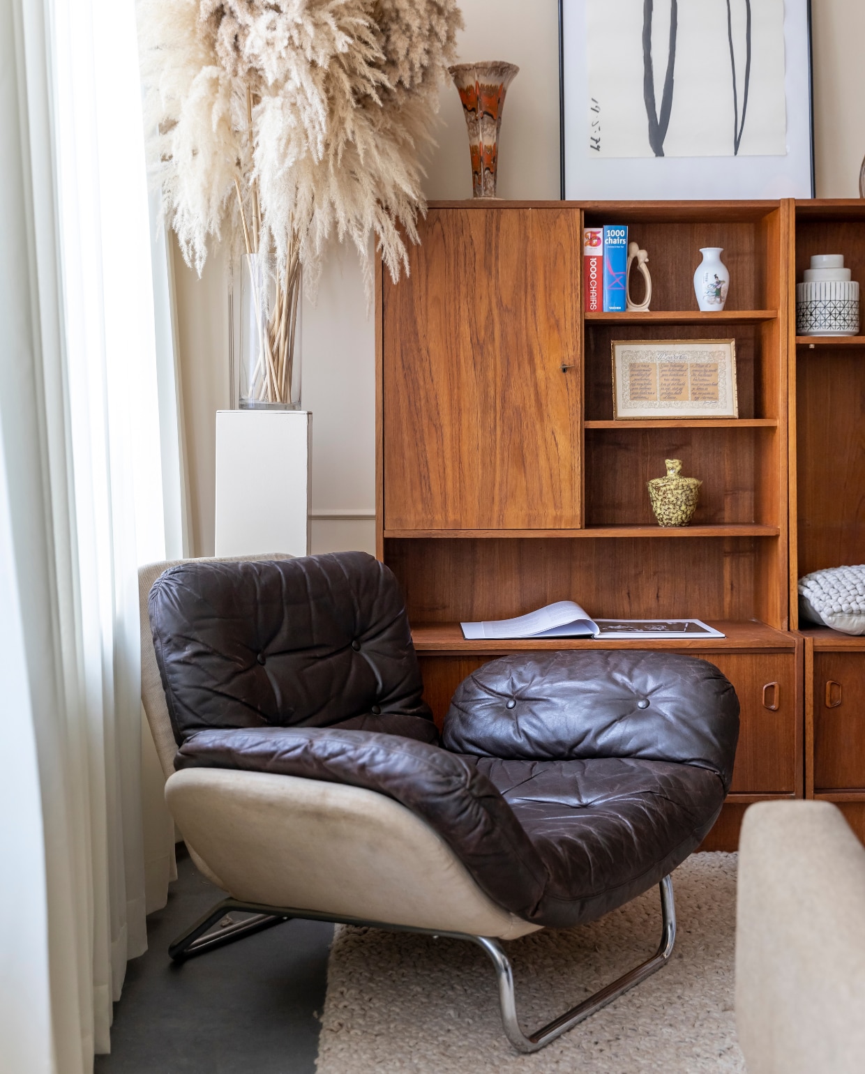 Vintage jaren 70-fauteuil, designer onbekend. Sokkel gemaakt door kennis, vaas kringloop, pluimen bloemist. Vintage jaren 60-wandmeubel Jeha. Jaren 70-kunstwerk kringloop. Vloerkleed vintage Marokkaanse berber. Vintage bank Rob Parry. Overig kringloop. vtwonen 08-2022 | styling Kesslee Kasius | fotografie Henny van Belkom