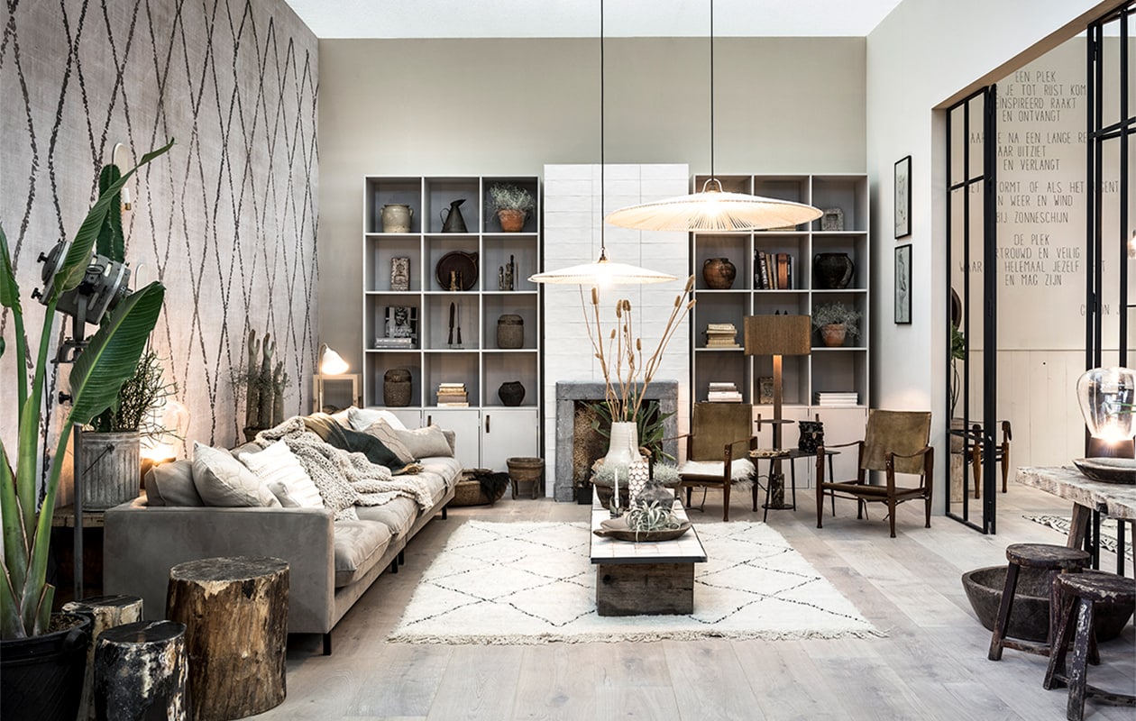 Muurverf op achterwand Flax, op rechter wand Linen, beide van vtwonen, per liter € 18,95 (karwei.nl). Tegels op schouw Mediterranea Nieve mat van vtwonen by Douglas &amp; Jones, 13,2×40 cm € 59,75 (vtwonen.nl/verkoopadressen). 3-zits bank Urban arm links en 3 zits-bank Urban arm rechts van vtwonen, in stof Brave 6 shitake, per stuk 192x73x95 cm (bxhxd) € 1099,- (vtwonen.nl/vtwonen-collectie). Witte vaas Tine K Home € 76,99, rubberen mand van Household Hardware € 33,50 (vtwonen.nl). Kasten prijs op aanvraag (com-anders.nl). Berber, 300×200 cm € 1290,- (rozenkelim.nl). Houten blokken per stuk € 75,- (oudebouwmaterialen.nl). Witte vloerlamp Bellevue van Arne Jacobsen€ 688,- (and-tradition.com). Graanmand China € 75,-, waterbak China € 75,-(dprtmnt.nl). Schapenvacht in mand € 95,-, hanglampen € 350,-, tafellamp € 350,- (homestock.nl). Houten tafel € 125,- (vandijkenko.nl). Krukjes per stuk € 245,- (neeflouis.nl). Houten schaal € 274,50 (rawmaterials.nl). vtwonen woonbeurs 13-2017 | fotografie Sjoerd Eickmans