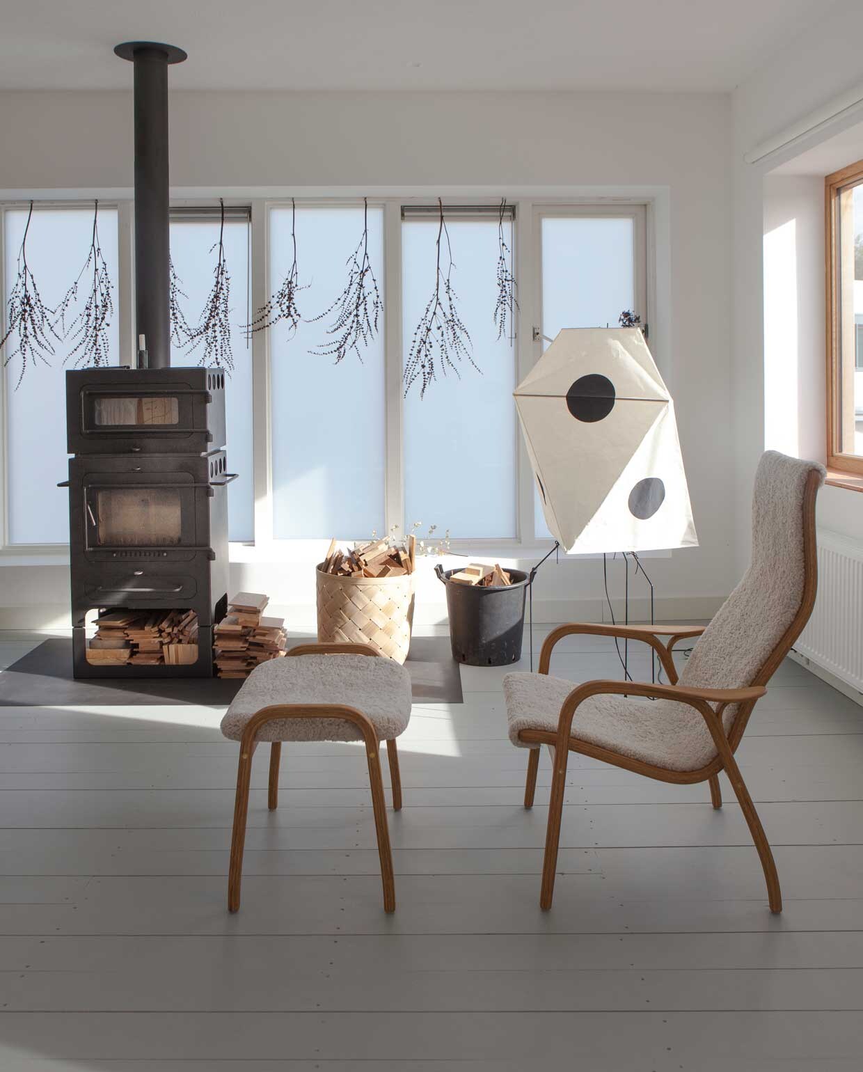 Ook in Christiens studio staan veel tijdloze klassiekers, zoals fauteuil en footstool Lamino van Swedese en de Akari Light Sculpture van Isamo Noguchi. Mand van Lillerod. In het bovenste deel van de houtkachel (van ABC) kun je brood bakken. vtwonen binnenkijken special 03-2020 | productie Taverne Agengy | fotografie Anna de Leeuw | Amber van Run