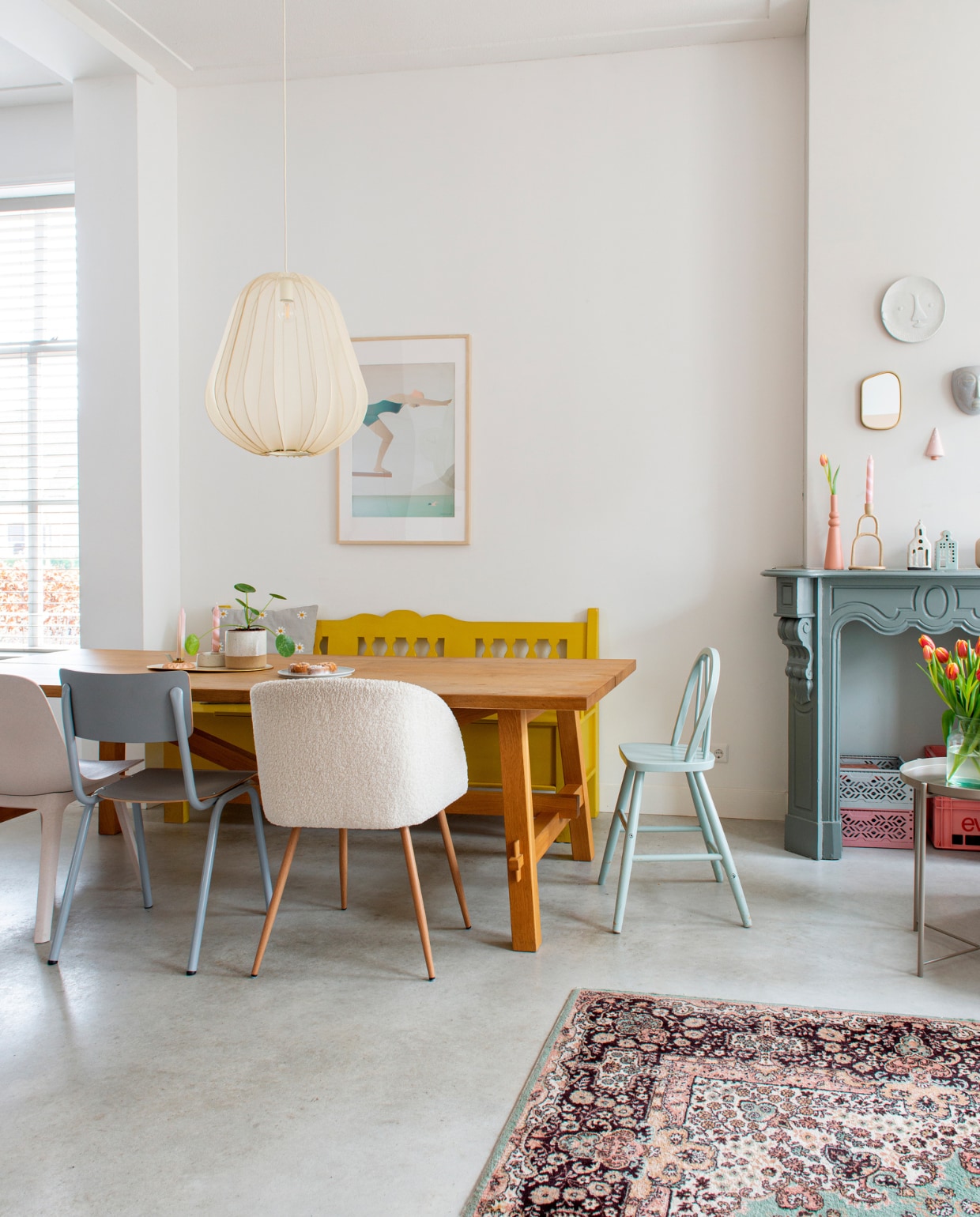 Tafel, beige stoel, kussen Ikea. Houten bank Oud is Nieuw. Grijze stoel Zuiver, vachtstoel Søstrene Grene, kinderstoel rommelmarkt. Hanglamp Bolia. Vloerkleed vintage. Poster Vissevasse. Bloempot Intratuin. Roze kandelaar Atelier-W, beige kandelaar op tafel Lagerhaus, kaarsen Plek conceptstore. Roze vaas en kandelaar op schouw Karwei, kerkje Xenos, huisje Hema. Wandbord Kwantum. Kerstboom Marleen Out. Vintage krat Evian @tweedesans. Verf schouw Early Dew van Flexa, grijze grondverf op schoorsteenmantel. Betonvloer. Overig onbekend. productie De Binnenkijkers | styling Jeske Weel | fotografie Caroline Coehorst | tekst Monique van der Pauw