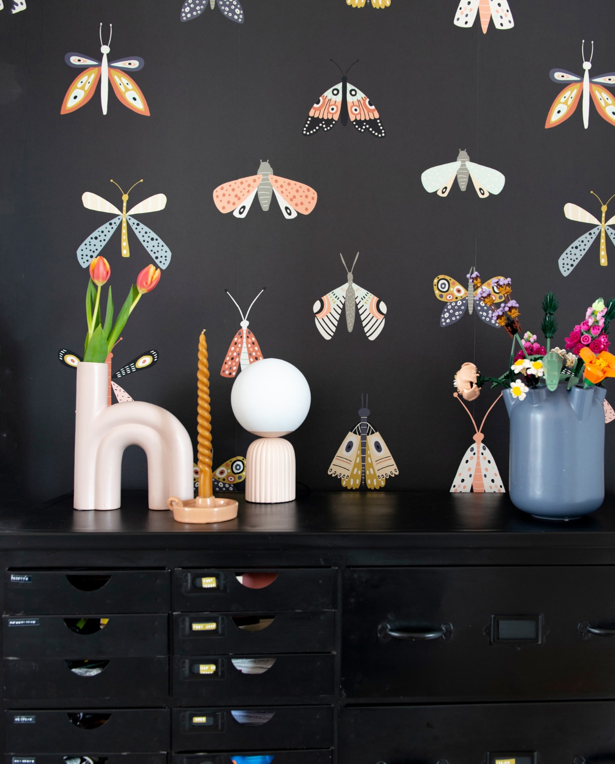 Behang vlinder Binnenzoet. Kast Gigameubel. Boogvaas Intratuin, tulpenvaas Hema, bollamp Kwantum, kaars Dille &amp; Kamille, bloemen Lego. Overig onbekend. vtwonen 08-2022 | productie De Binnenkijkers | styling Jeske Weel | fotografie Caroline Coehorst