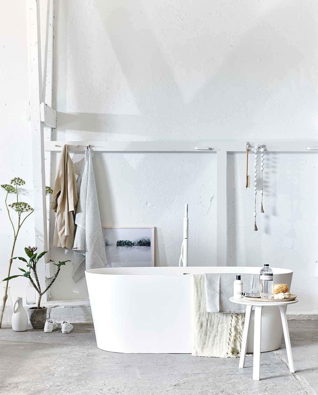 Vrijstaand bad Tub van vtwonen 165x72x60 cm, vrijstaande badmengkraan Curve (www.vtwonen.nl/vtwonen-collectie). Tafel Bella (Hay Amsterdam). Afbeelding Calm Botanics in lijst, 50×70 cm exclusief lijst, grote fles geurwater van Marie-Stella-Maris, kleine fles, badborstel, linnen badlakens No.6 (My Deer’s). Kralenketting (Couleur Locale). Linnen jas (Six and Sons). Linnen doek met franjes (De Weldaad). Labfles (Neef Louis). Kapstok met haken vanaf (Combitex). Houten schaal (HK Living). Natuurspons (&amp;Klevering). Gympen (Acne Studios). Overig privébezit. JA vtwonen 07-2017 | styling Cleo Scheulderman | fotografie Jeroen van der Spek