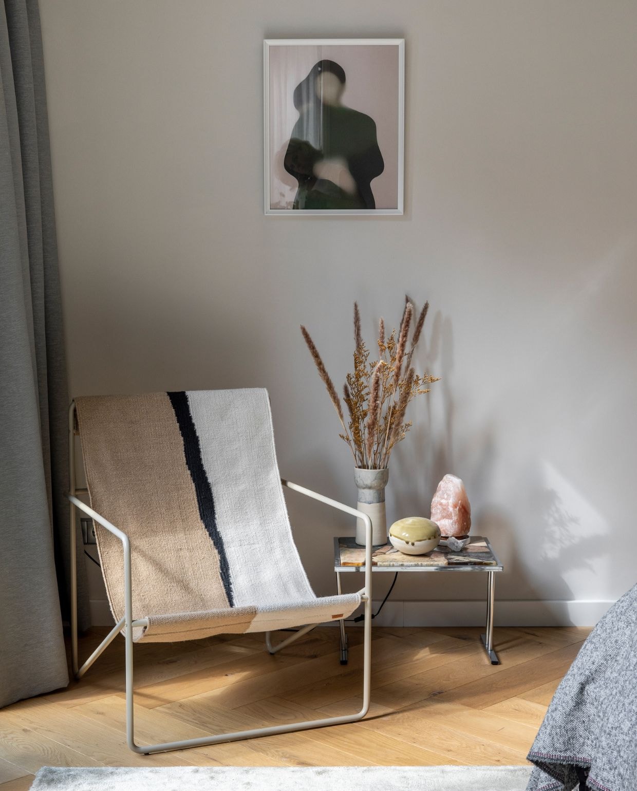 Muurverf Skimming Stone van Farrow &amp; Ball. Gordijn Ikea. Vloer blank geolied eikenparket vtwonen. Stoel Desert Chair van Ferm Living, bijzettafel vintage, designer onbekend, zoutlamp, keramiek Studio Amber Isabel. Vloerkleed Wehkamp. Kunstwerk art print van Gurilla. vtwonen 07-2022 | productie CocoFeatures | styling Brenda van Roekel - Studio Amber Isabel en Lotje Deinum | fotografie Denise Zwijnen | tekst Saskia Borst