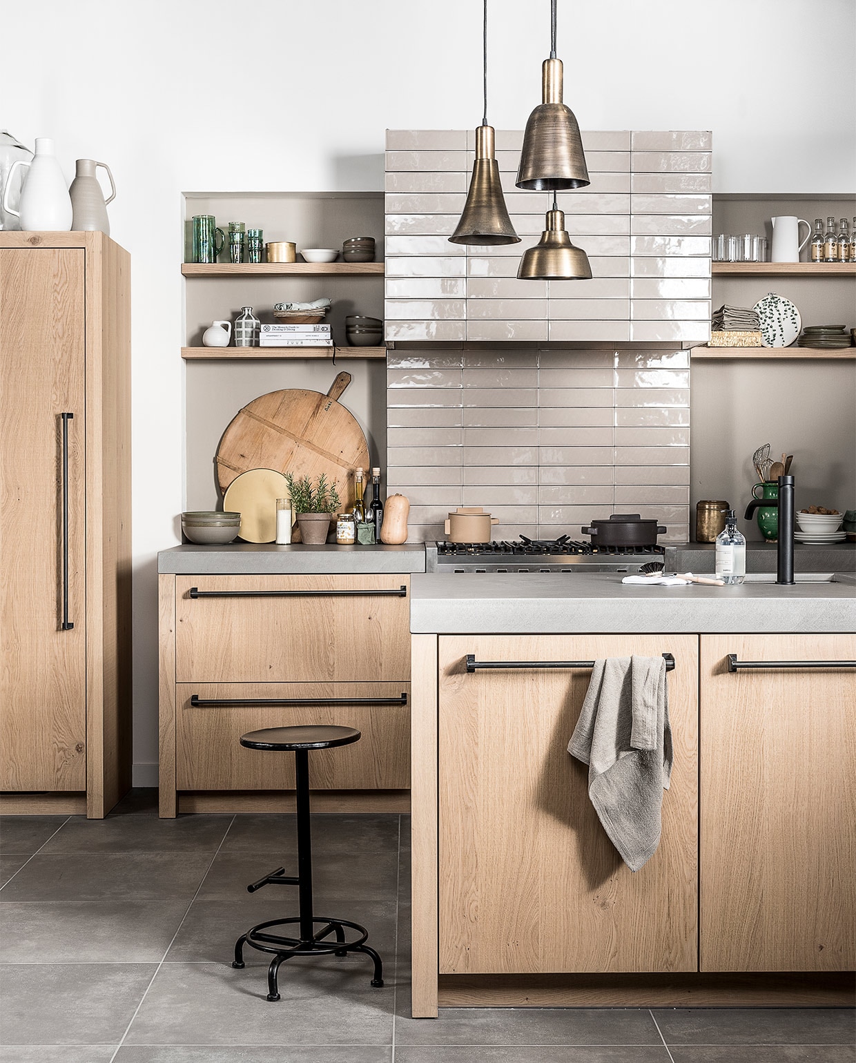 Hanglamp Shine, Glow en Bloom van vtwonen in brons per stuk € 59,95mandemakers (keuken), &amp;klevering (groene glazen kan, groene glazen, kookboeken, aanrechtdoekje), six and sons (messing opbergbox, messing kandelaar), nijhof (groen servies, groen vaasje met witte strepen, groene linnen servetten, pannen, witte kan, gespannen doek met blad- illustratie, groene opbergzak, gouden vaas), loods 5 (zeeppompje, afwasborstel, oud messing blik, gouden opbergbox, houten snijplank op pootjes), De weldaad (oude groene stenen kan). koperen draadmand, linnen schorten, ecru en witte kannen, flesvaas, gouden schaal, kruk, hanglampen, glazen, wit servies, theedoeken, rolgordijn en memo/magneetbord van vtwonen. Overig privébezit. JA vtwonen 07-2017 | styling Danielle Verheul | fotografie Sjoerd Eickmans