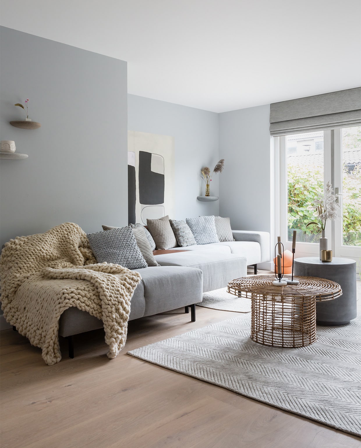 Muurverf Wild Dove, bij de ramen Silver Shadow (flexa.nl). Vouwgordijnen LF035 Simply Grey prijs op aanvraag (jasno.nl). Print aan de muur Wallpower Bold, 150×150 cm (hxb) € 145,- (eijffinger.com). Wandplankjes Stones, set van 3 € 295,- (bogaertslabel.com). Bank prijs op aanvraag, betonnen salontafel € 139,-, salontafel Nature € 209,- (eijerkamp.nl). Vintage stoel € 495,- (bestwelhip.nl). Vloerkleed Viscose Sage € 542,50, rond vloerkleed € 382,50, grof gebreide plaid € 214,50, lichtgrijs leren kussen € 27,50, fluwelen kussen € 26,95 (rocaflor.nl). Pot In your face € 6,99, marmeren kaarsenhouders, per stuk vanaf € 6,99 (housevitaminshop.nl). Vloerlamp € 290,-, vaas Balloon € 46,75, schapenvacht € 79,- (vtwonen.nl). Radiatorombouw zelfgemaakt. Droogbloemen, planten (scheepstrabloemen.nl). Vaas € 12,- via kringloopwinkel De Oude Markt Naarden. Overig privébezit. JA | vtwonen weer verliefd op je huis | seizoen 11, aflevering 7 | styling Eva van de Ven | fotografie Barbara Kieboom