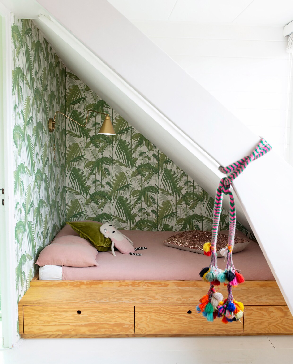 Op de kamer van Maggie een wandrek met bureau van String. Print van Parijs door Famille Summerbelle, Batgirl-print van Mini &amp; Maximus, stoel van een rommelmarkt. Links in het rek modernistisch poppenhuis Villa Sibis van Sirch. Poppetjes van Petit Depot, karpet uit Marokko, lamp House Doctor, kledingkast vintage. Herkomst overig onbekend. Beeld: styling JESKE WEEL | fotografie CAROLINE COEHORST | tekst CHRIS MUYRES