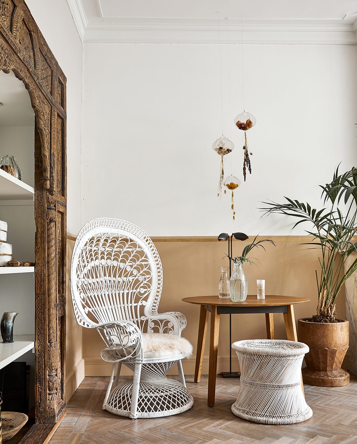 Oude poort meegenomen uit India. Pauwstoel, manden, plantentafels en zelf wit gespoten kruk Zenza. Overige in kast souvenirs, vintage vondsten en dierbare items, zoals een naaidoos die Karins opa heeft gemaakt. Tafel Raw Materials. vtwonen 06-2021 | productie Coco Features | styling Linda van der Ham | fotografie Peggy Janssen