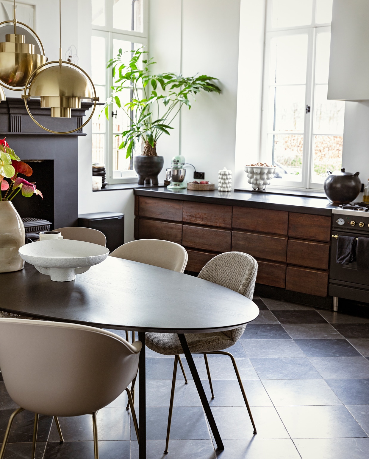 Tafel Studio Henk. Plafondlampen en stoelen Bat en Beetle van Gubi via Interior Playground. Schaal Serax. Kaars l’Objet. Vaas Casa Gitane. Schilderij Art in Return. Plantenpot Ames Design. Op het aanrecht: schaal Ferm Living. Koekjespot en schaal Jonathan Adler. Pan Indigena Fine Folk Art. vtwonen 11-2021 | styling Ilona Jongepier | fotografie Dana van Leeuwen