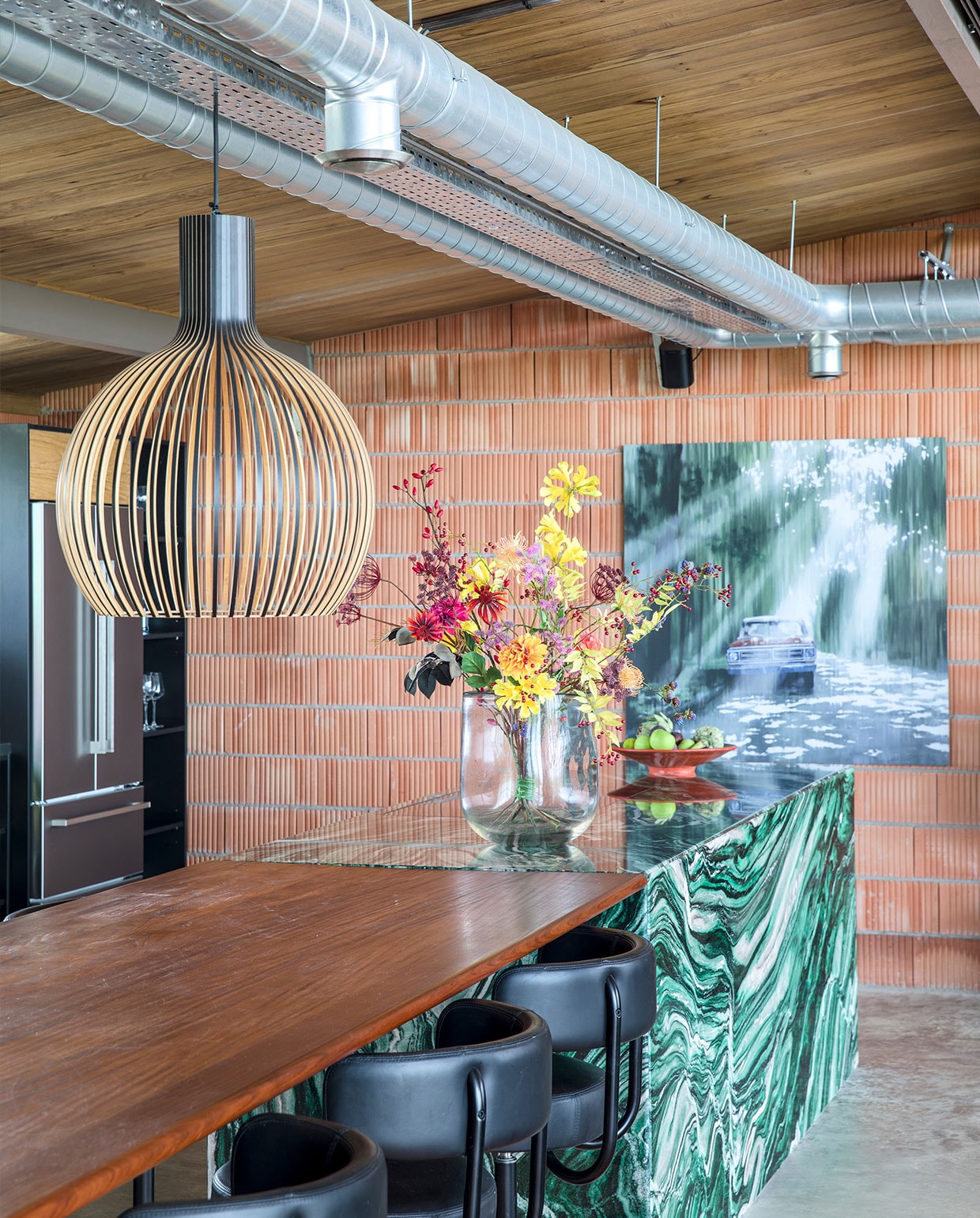 De muur bestaat uit onbewerkte snelbouwstenen. Plafond en eettafelblad van Fraké Noir-hout. Kookeiland van Noors kwartsiet Hafkamp Natuursteen. Barkrukken Arthur Eltink Agencies. Vaas Dutz, kunstbloemen Ten Kate flowers &amp; decorations. Hanglamp Octo Secto Design. Kunstwerk Jan Ros. vtwonen special binnenkijken 03-2022 | fotografie Margriet Hoekstra