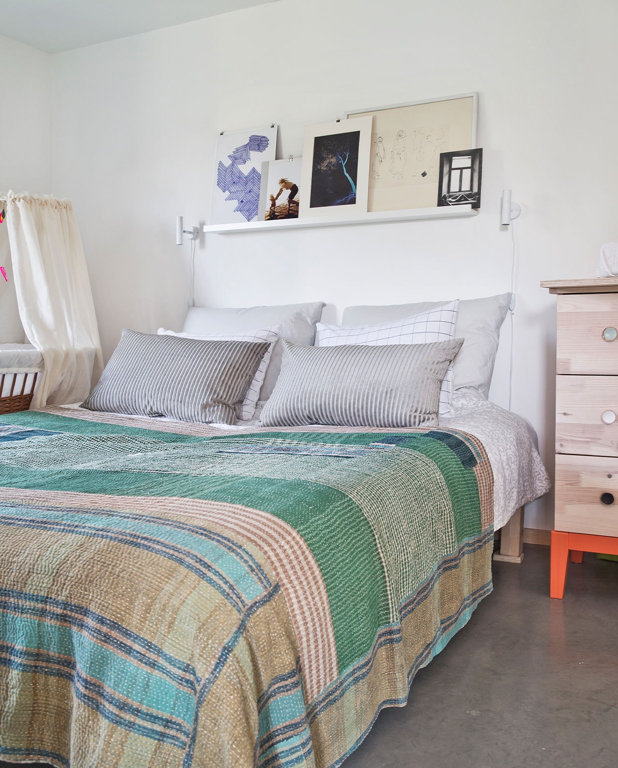 Bed en ladekast Ikea. Beddengoed Hay. Wieg kringloop. Bedlampjes Nordlux. Wandplank Ikea, daarop een mix van ingelijst eigen werk en brocantevondsten. NEE | vtwonen 7-2022 | Productie Living Inside | Styling Rikke Graff Juel | Fotografie Christina Kayser O. | Tekst Christina B. Kjeldsen | Tekstbewerking Sunna Borghuis