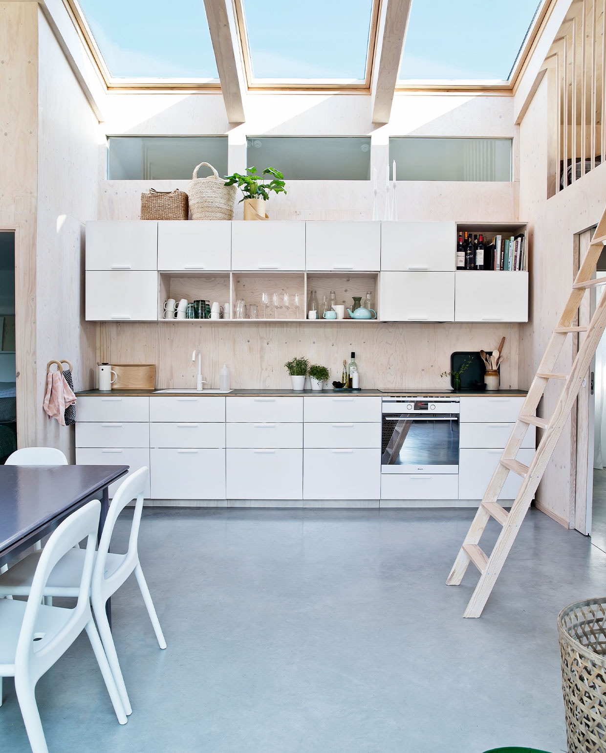 Keukenkastjes Ikea, zelfgemaakt aanrecht van linoleum. Oven Gram. Manden Madam Stoltz, witte koffiekan Stelton, snijplank en witte bekers Ikea, glaswerk Iittala. Serviesgoed, theepot, plantenpotjes kringloop en brocante. Handdoekrekken Hay. Ladder Trævarefabrikernes Udsalg. Eettafel kringloop, stoelen Ikea. Overig herkomst onbekend. NEE | vtwonen 7-2022 | Productie Living Inside | Styling Rikke Graff Juel | Fotografie Christina Kayser O. | Tekst Christina B. Kjeldsen | Tekstbewerking Sunna Borghuis