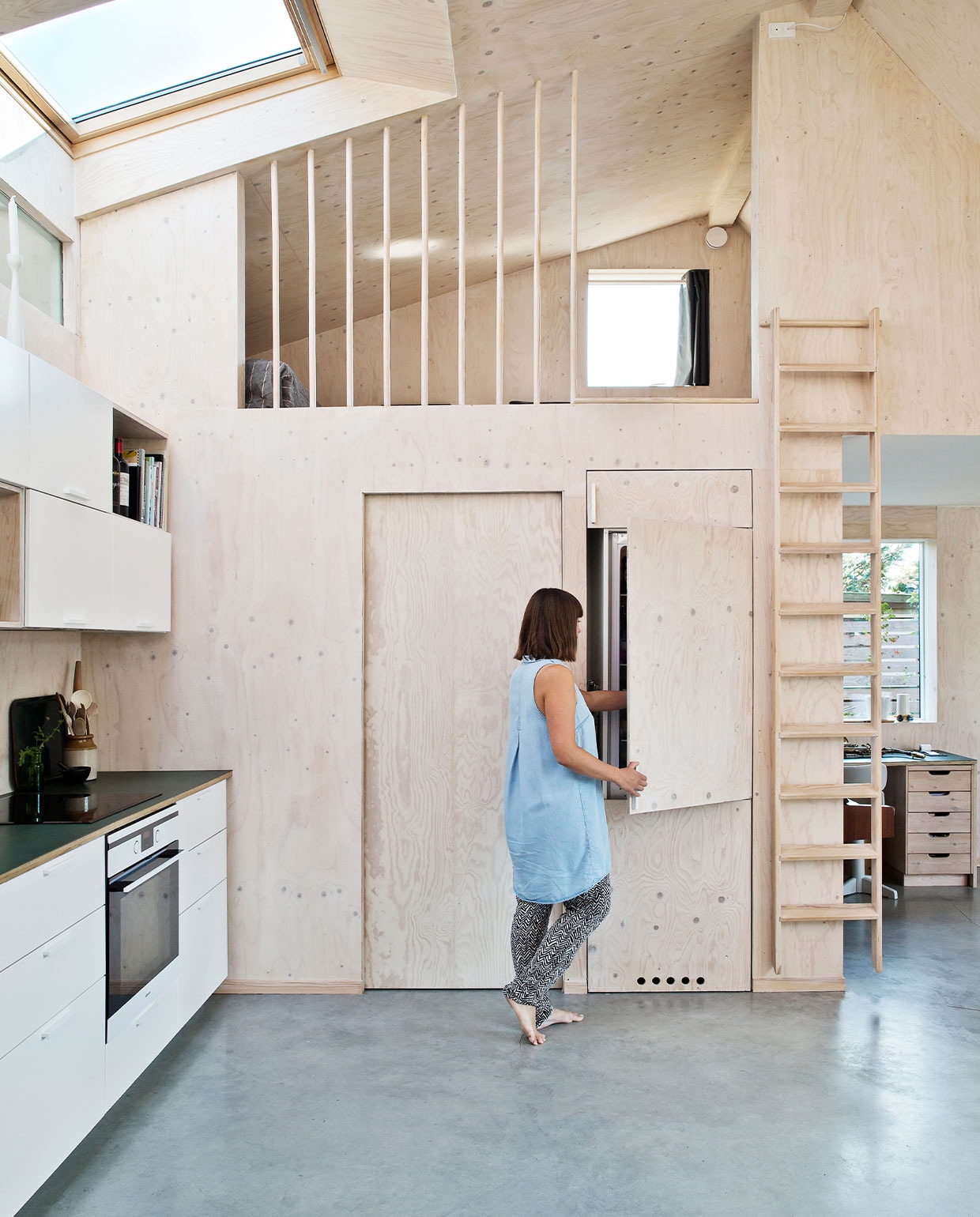 Keukenkasten Ikea, zelfgemaakt aanrecht van linoleum, oven Gram. Ladder Trævarefabrikernes Udsalg. Bureau eigen ontwerp. Betonnen gietvloer uit Denemarken. NEE | vtwonen 7-2022 | Productie Living Inside | Styling Rikke Graff Juel | Fotografie Christina Kayser O. | Tekst Christina B. Kjeldsen | Tekstbewerking Sunna Borghuis