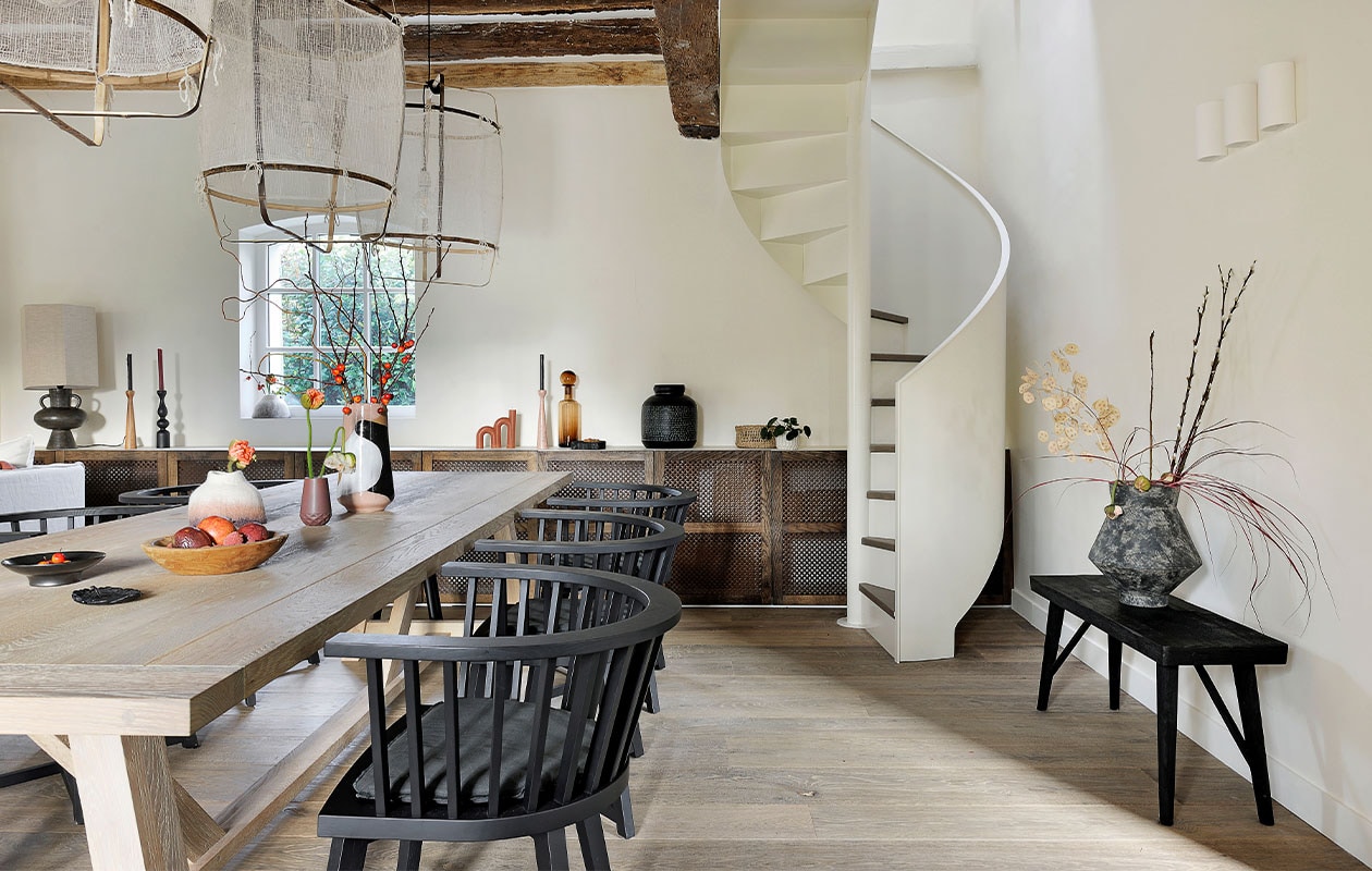 Tafel Arundel Neptune. Stoelen Bridge Gray Paola Navone voor Gervasoni. Lampen Z1 Black Ay Illuminate. Grote vaas op tafel en tafellamp HKliving. Lage vaas Fusion Muskhane. Houten schaal Rochel Habitat. Kandelaren Kinta Atelier Germain. Karaf gerookt glas en boogkaars Fleux. Zwarte vaas Passage Vernet. Bankje H&M Home. Vaas Greek Terracotta 101 Copenhagen. Overig onbekend.