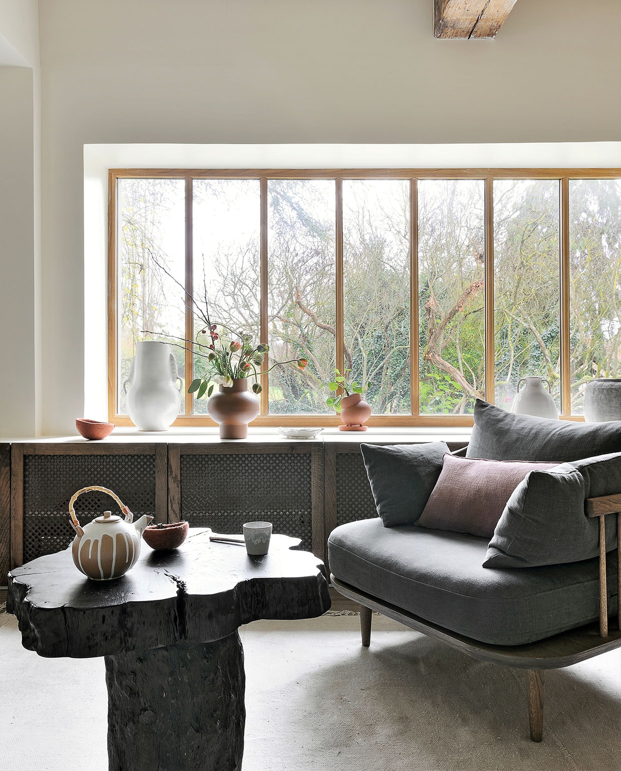 Bijzettafel Opiki AM.PM. Vloerkleed HKliving. Fauteuil Fly Space Copenhagen voor &Tradition. Bruine vaas Bulbe Atelier Germain. Theepot, mok en kom Fleux. Overig onbekend. vtwonen special binnenkijken 03-2022 | fotografie Frenchie Cristogaton
