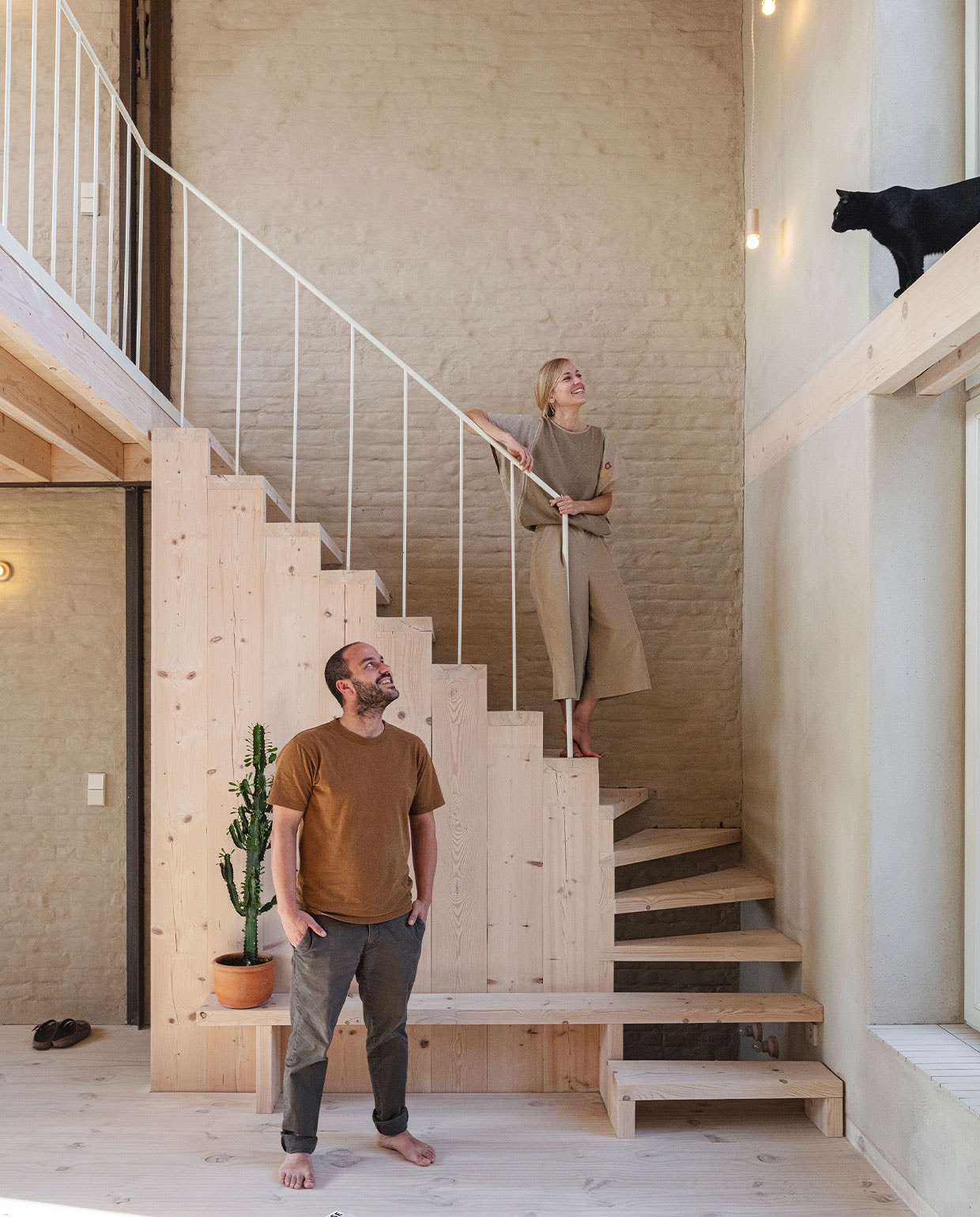Hanne, Nicolas en kat Tino bij de zelfgebouwde trap van ecologisch geloogd en gezeept grenen van Woca. NEE | vtwonen 7-2022 | fotografie Tim Van de Velde | tekst Iris De Feijter | tekstbewerking Chris Muyres