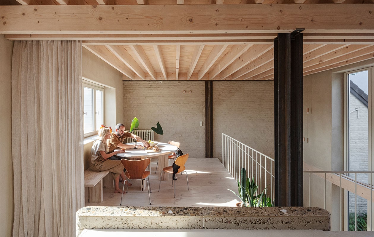 Tweedehands Mier- en Vlinderstoelen van Arne Jacobsen, tafel en bank zelfgemaakt met overgebleven hout van de vloer. De vloeren en plafonds zijn van grenen van Woca en ecologisch verantwoord geloogd zodat het niet verkleurt. Woca gebruikt ook een zeep waarmee de vloeren vuilwerend zijn. Gietijzeren radiator geërfd van Hanne’s oma. NEE | vtwonen 7-2022 | Fotografie Tim Van de Velde | Tekst Iris De Feijter | Tekstbewerking Chris Muyres