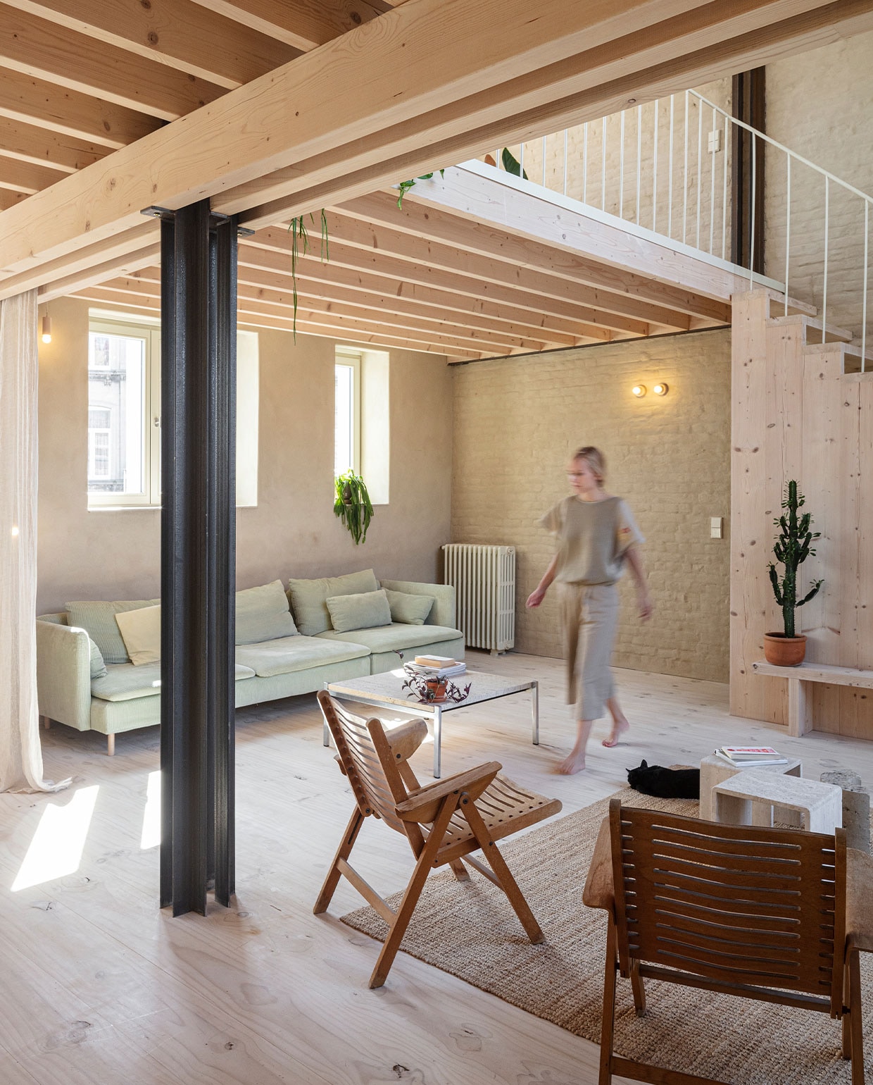 Stoelen Niko Kralj. Salontafel en travertijnen bijzettafels tweedehands. Vloerkleed en bank met hoes van Bemz Ikea. Gordijnen Zara Home. Houten bank zelfgemaakt. Vensterbanken Oslo White steenstrips van Roben. Lampen gemaakt door de vader van Nicolas. Gietijzeren radiator geërfd van Hanne’s oma. NEE | vtwonen 7-2022 | fotografie Tim Van de Velde | tekst Iris De Feijter | tekstbewerking Chris Muyres