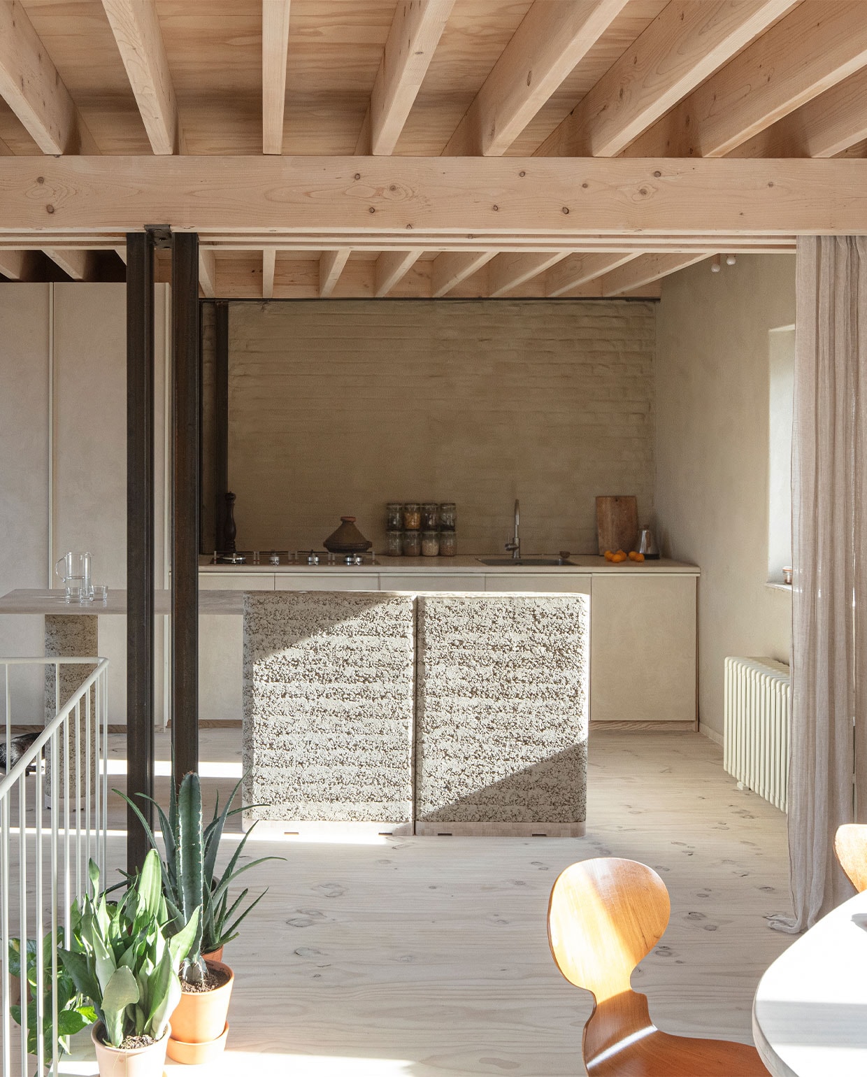 Keuken zelfontworpen en gebouwd met kranen en wasbak van Reginox, apparatuur Smeg, schakelaars Jung. Het muurtje op de voorgrond is van rammed earth, een materiaal van hergebruikte grondstoffen van BC Materials. Gietijzeren radiator geërfd van Hanne’s oma. NEE | vtwonen 7-2022 | fotografie Tim Van de Velde | tekst Iris De Feijter | tekstbewerking Chris Muyres