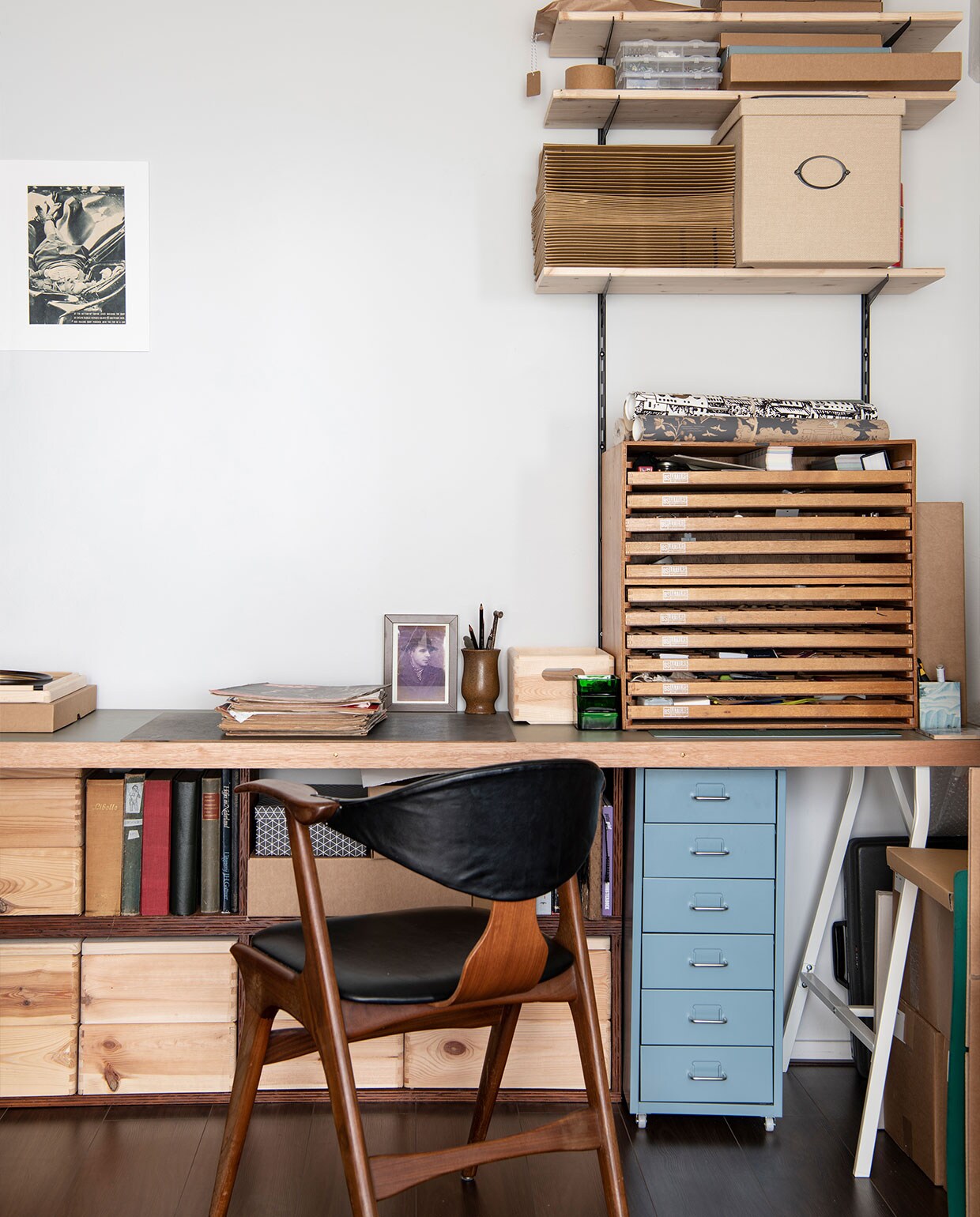 Bureau en ladekast op bureau kringloop, blauwe ladekast Ikea, stoel Louis van Teeffelen, houten opbergboxen Hornbach, kunst aan de muur The most beautiful suicide uit Life Magazine. Overig onbekend. NEE | vtwonen 6-2022 productie Insidehomepage | styling Kim Timmerman | fotografie Louis Lemaire  | tekst Anne-Flore Muller