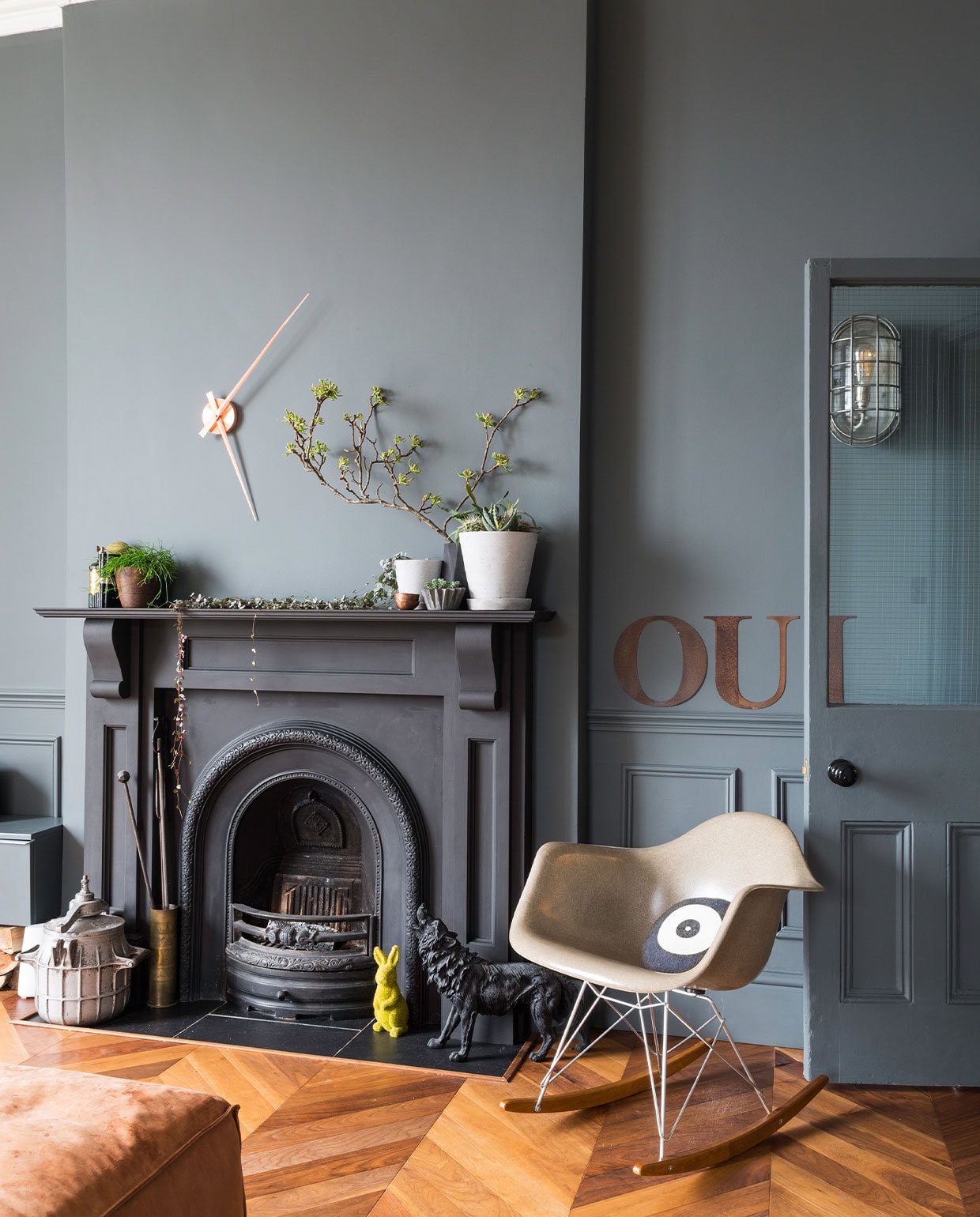Muurverf Estate Emulsion Down Pipe van Farrow &amp; Ball. Klok Karlsson, konijn Hobbycraft, wolf Seletti. Eames-stoel Vitra. Metalen letters Cachette. Wandlamp Trainspotters. Vloer Hicraft. Overig onbekend. NEE | vtwonen 5-2022 | fotografie Kasia Fiszer | tekst Jo Leevers | tekstbewerking Saskia Borst
