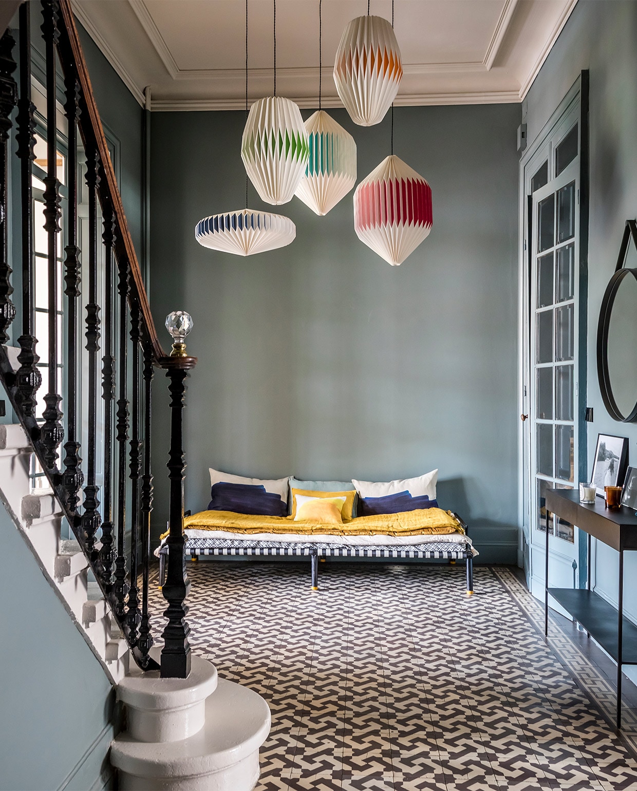 Muurverf Gray Stone van Little Greene. Papieren hanglampen Sentou. Charpoï-bankje, matras en plaid Le Monde Sauvage, kussens Jacques Design via La Gaité. Wandtafel AM.PM via La Redoute. Spiegel Hay. Kandelaar Sarah Lavoine. De originele vloertegels zaten al in het huis. vtwonen special zomerhuizen 07-2021 | productie &amp; tekst Anne-Catherine Scoffoni | styling Marie-Maud Levron | fotografie Cecile Perrinet-Lhermitte | tekstbewerking Monique van der Pauw