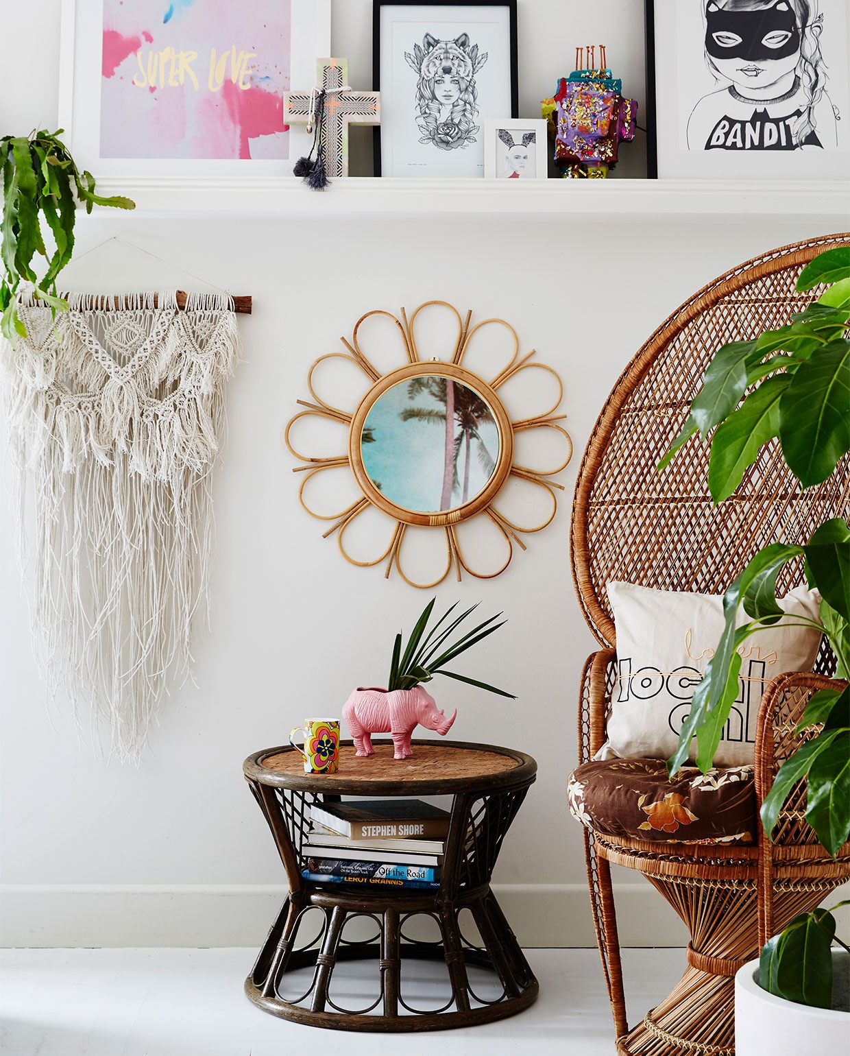 Macraméwandhanger Family Threds. Rotan spiegel @downtothewoods. Bijzettafel en stoel gevonden op straat, wit kussen Kawaiian Lion. Roze neushoornplantenpot Rice dk. Op plank: keramieken kruis met hanger Ahoy Trader, print Bandit Girl Mini &amp; Maximus. Plant in pot Olive Green Plant &amp; Prop. Overig onbekend. vtwonen binnenkijken special 07-2021 | Styling Julia Green en Noel Coughlan | Fotografie Armelle Habib | Tekst Julia Green | Tekstbewerking Caroline Westdijk