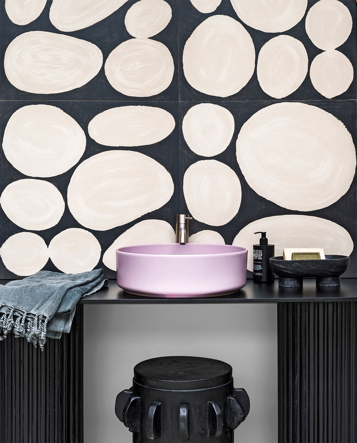 Tegels Kiezel negative, mat 60×60 cm per m2 € 145,-, ronde wasbak van keramiek in lila € 933,-, kraan € 343,- (intercodam.com). Ovale tafel met zuilen, 160x30x65 cm (lxbxh) € 695,- (hkliving.nl). Massief houten kruk € 250,- (casagitane.com). Schaal Alza van Ferm Living € 119,- (vtwonen.nl). Vloeibare handzeep € 7,95 (mijnstijl.com). Zeep Seaweed € 20,- (haeckels.co.uk). Hamamdoek privébezit. vtwonen 10-2019 | styling Marianne Luning | fotografie Stan Koolen