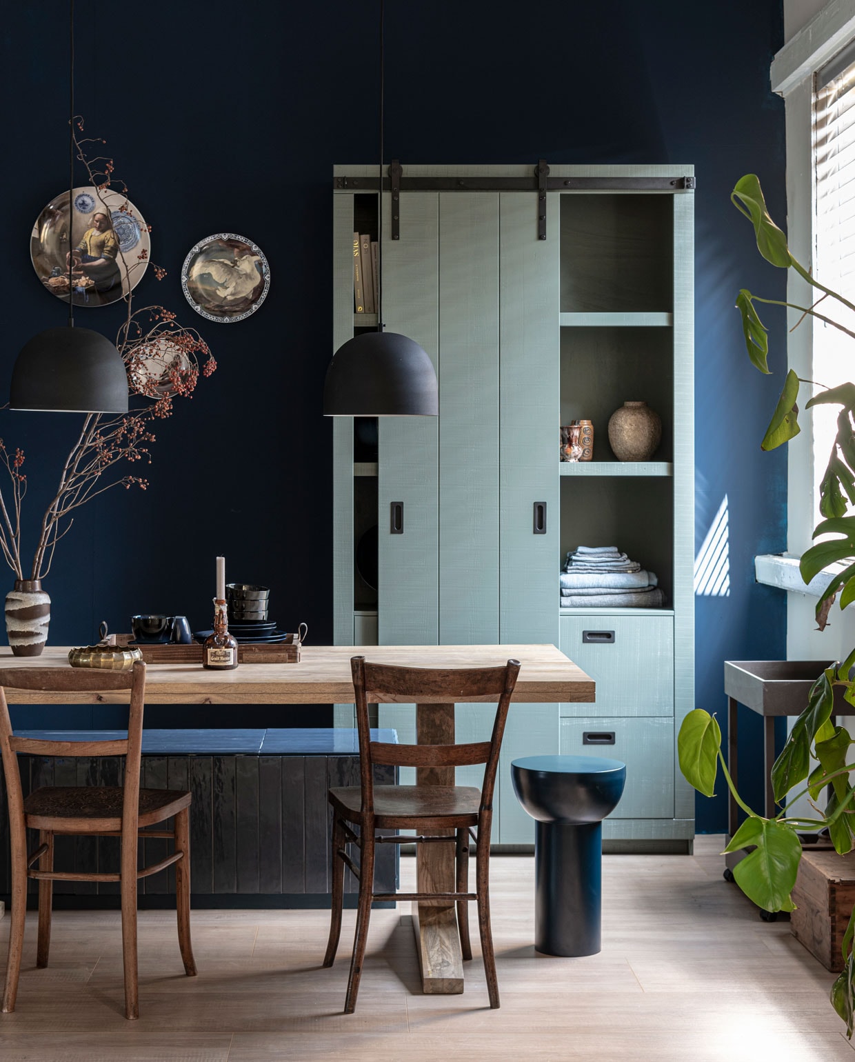 Muurverf Midnight en Soap (op kast) van vtwonen. M.m.v. vtwonen.nl (schuifdeurkast Slide in kleur Soap, eettafel Deck, tegels op de bank Marrakesh in Ocean Blue glans, hanglamp Sphere, blauwe kruk/bijzettafel Metal Matt, dienblad Family en donkerblauw servies van vtwonen), karwei.nl (vloer Laminaat XL Rafter, jaloezie op maat in kleur A18051). Overig privébezit. vtwonen 08-2022 | styling Marianne Luning, Fietje Bruijn, Cleo Scheulderman, Kim van rossenberg | fotografie Stan Koolen, Jeroen van der Spek, Dennis Brandsma, Sjoerd Eickmans