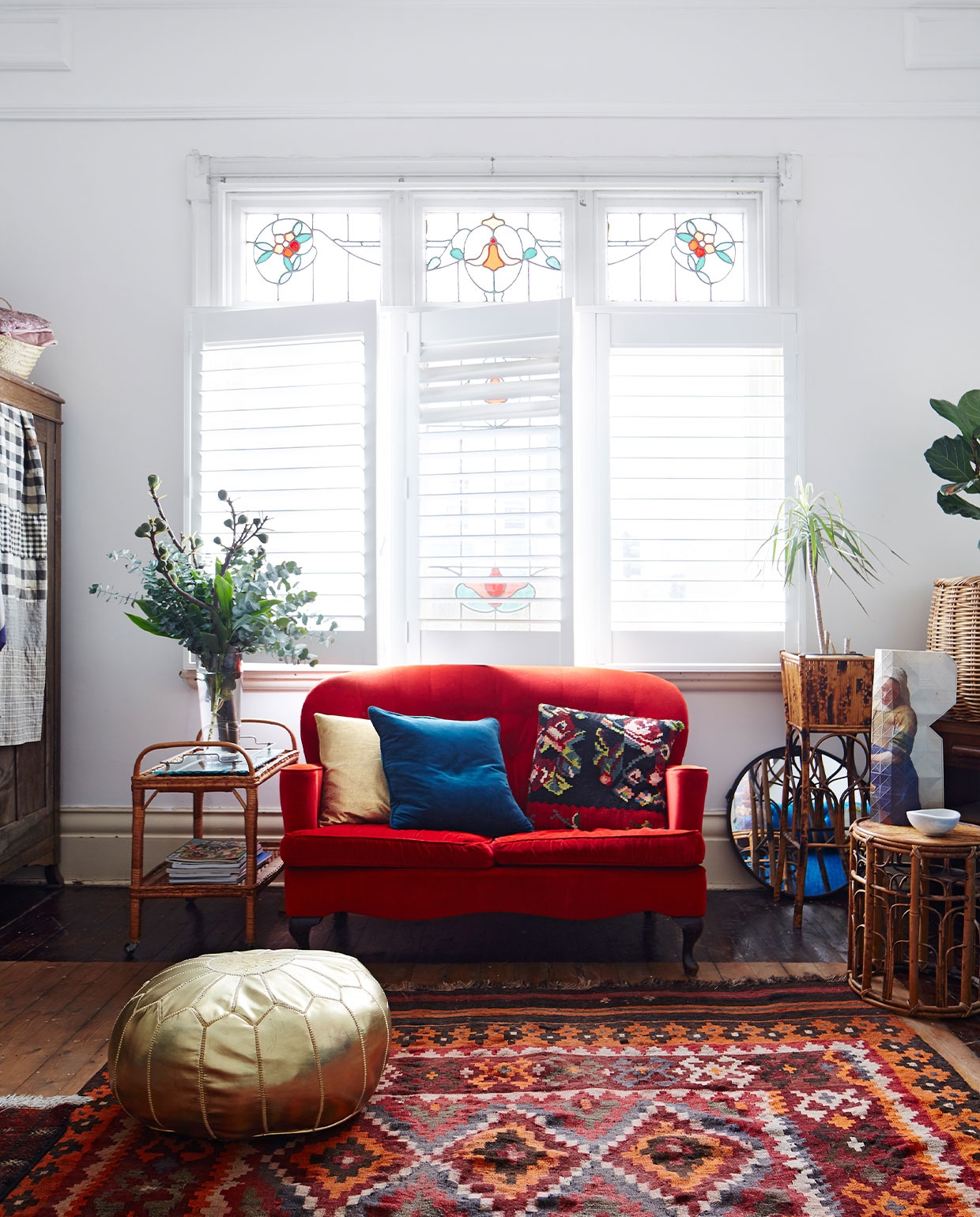 Rode fluwelen bank vintage, zelf opnieuw bekleed. Goudkleurige leren poef Etsy. Overig vintage. vtwonen 06-2022 | productie Living inside | styling Julia Green | fotografie Armelle Habib
