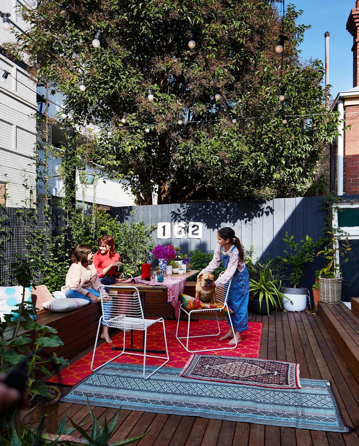 Buitenlichtsnoeren Luxform. Vergelijkbare tuinstoelen via vtwonen. Outdoor kelims en perzen Interliving, Rozenkelim. Overig onbekend. vtwonen 06-2022 | productie Living inside | styling Julia Green | fotografie Armelle Habib