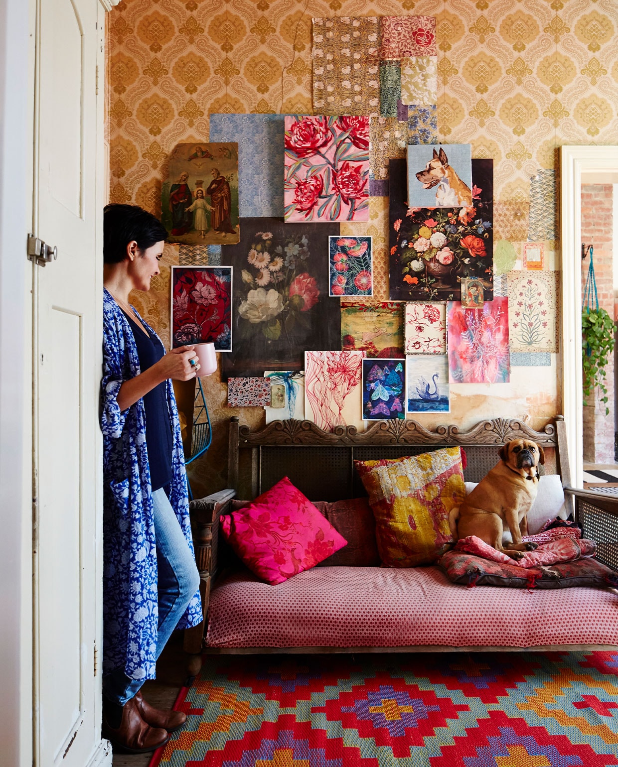 Paula Mills en hond Bella. Seventiesbehang van vorige bewoners, vergelijkbaar behang Praxis. Turquoise barkruk Bend Goods. Houten bank antiek, zelf opnieuw bekleed. Buitenkelim Interliving. Kussens Etsy van vintage stof. Kunst Paula Mills. Overig vintage of onbekend. vtwonen 06-2022 | productie Living inside | styling Julia Green | fotografie Armelle Habib