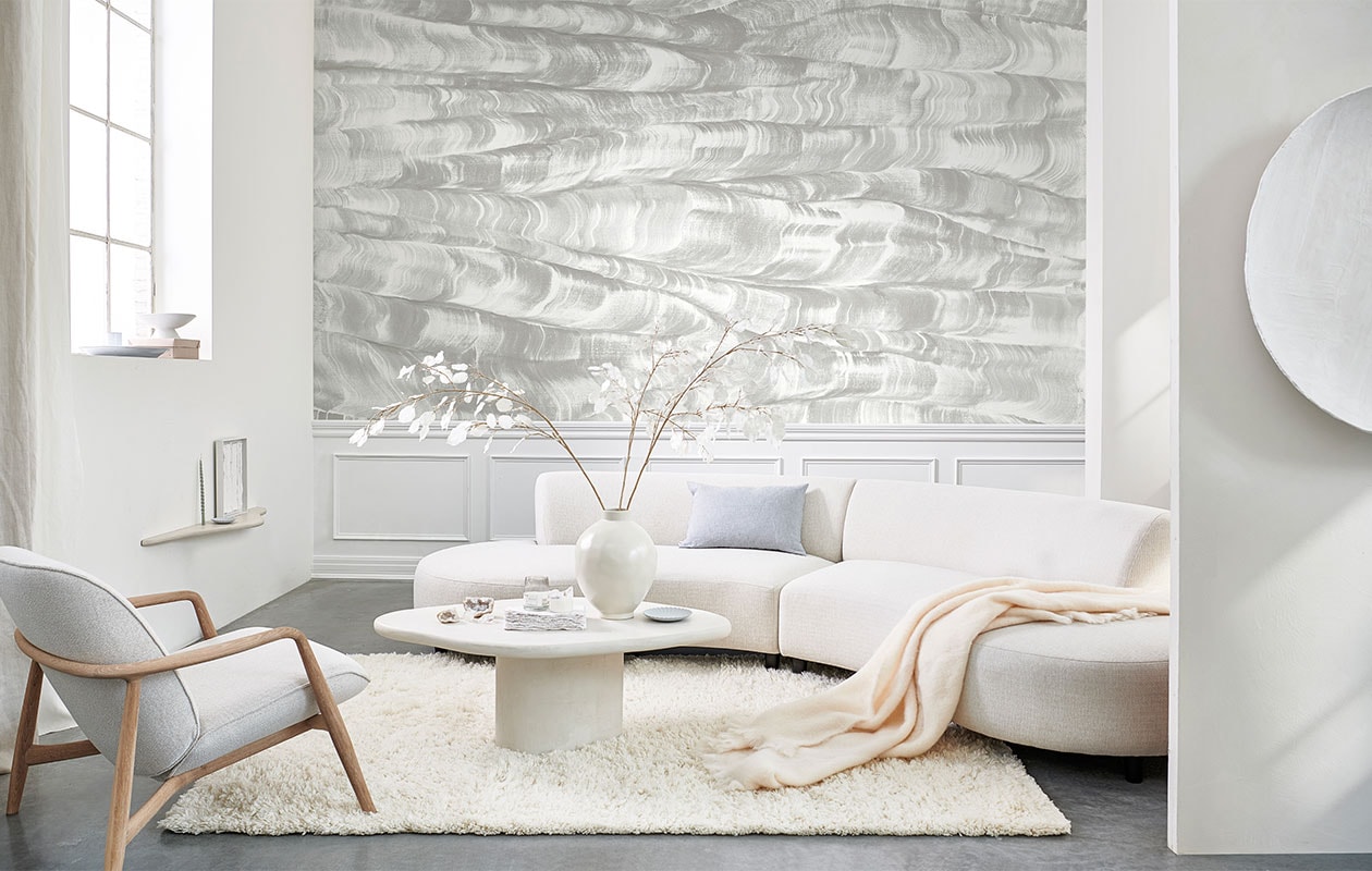 Paneelbehang Sand Waves uit de collectie Geo van Coordonné, per m2 vanaf € 60,- (van-sand.com). Kalkverf op wand kleur Lava White, vanaf 1 liter € 55,- (pure-original.nl). Fauteuil € 2299,- (bolia.com). Gordijnen gemaakt van linnen stof Brera Lino van Designers Guild, prijs per meter € 86,- (wva.nl). Vloerkleed van Linie Design € 715,- (vtwonen.nl). Ovale schaal € 12,99 (hm.com). Schaal op voet € 44,95, vaas € 59,95 (urbannatureculture.com). Pleisterwerk wandplank € 140,- pleisterwerk salontafel € 640,- (velv.nl). Blauwe gedraaide kaars, set van twee € 4,50 (paviljoennoord.com). Kunstwerk in lijst € 450,-, rond kunstwerk aan wand € 1100,- (julyadrichem.com). Bord € 19,90 (letoile.store). Bank, 187×155 cm (bxd) € 2295,- (loods5.nl/eigen-collectie). Linnen kussen, vanaf € 39,- (bymolle.com). Wollen plaid € 119,- (zarahome.com). Overig privébezit. vtwonen 06-2022 | Styling Danielle Verheul | Fotografie Sjoerd Eickmans | Assistentie Sanne Ketelaar, Minke van Bakel