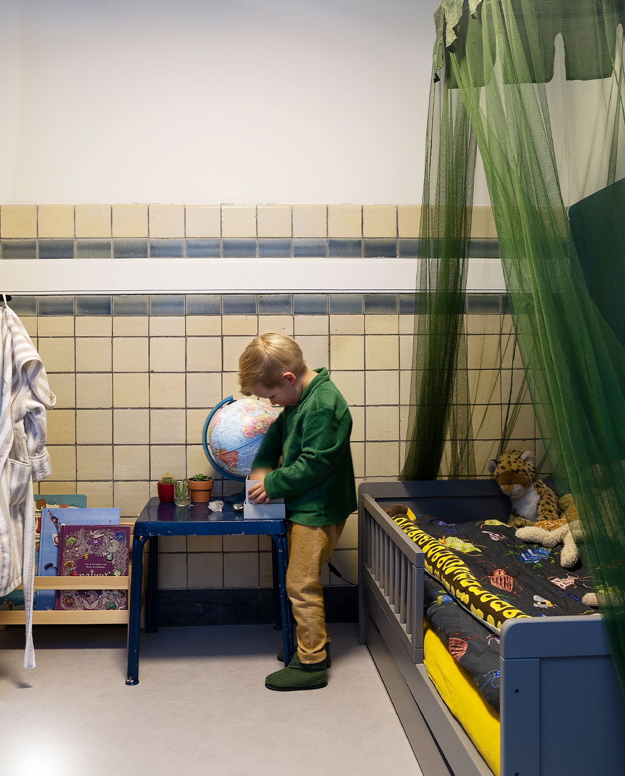 Kinderbed Petit Amélie, beddengoed Wehkamp, klamboe Deconet, knuffelslang Wild Republic, luipaard cadeau. Boekenrek Ikea, speeltafel cadeau. Ochtendjas Zara. Vloer Marmoleum van Forbo. Muurverf Lois van Fairf. vtwonen 06-2022 | productie Martine Benjamins | styling Emmy van Dantzig | fotografie Jansje Klazinga