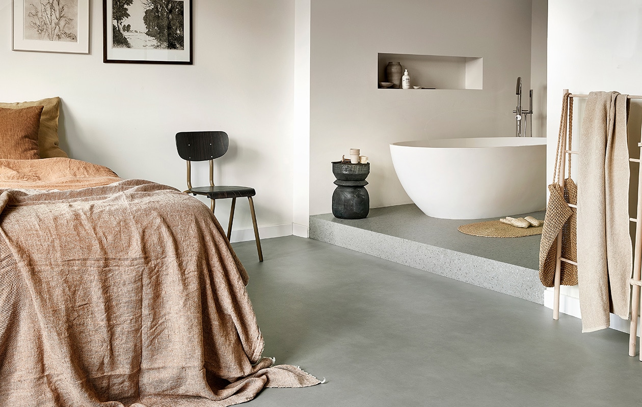 Novilon vloer slaapkamer Kalk per m² € 29,50. Novilon vloer badkamer Mineraal per m² € 29,50.M.m.v. basiclabel.nl (houten kruk), skins.nl (shampoo van Le Labo), letoile.store (wit schaaltje, zeep, huisgeur), bymolle.com (houten droogrek), sostrenegrene.com (handdoek), zarahome.com (ovale juten mat), dille-kamille.nl (houten kam, tandenborstel). Overig privébezit. vtwonen 07-2021 | productie Tanja Saarberg | styling Marlies Does | fotografie Peggy Janssen