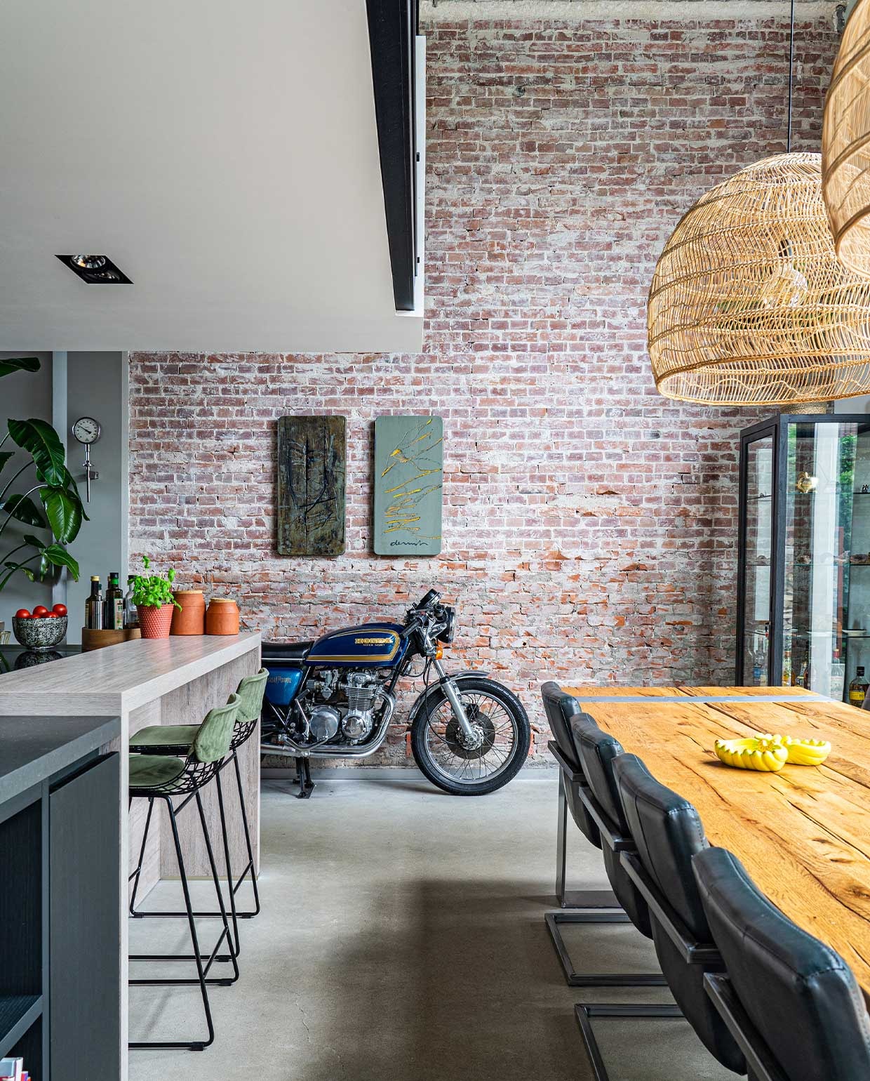 Eettafel Iccoon, stoelen van een veiling, lampen en barkrukken HKliving, kunst Wiegen den Uyl, motor Honda, bar Piet Boon Kitchen. Op tafel bananenschaaltjes Tigerwoods. Potten op bar Made, overig onbekend. vtwonen 01-2022 | styling Kundertje Hamstra, Iris Floor | fotografie Iris Floor