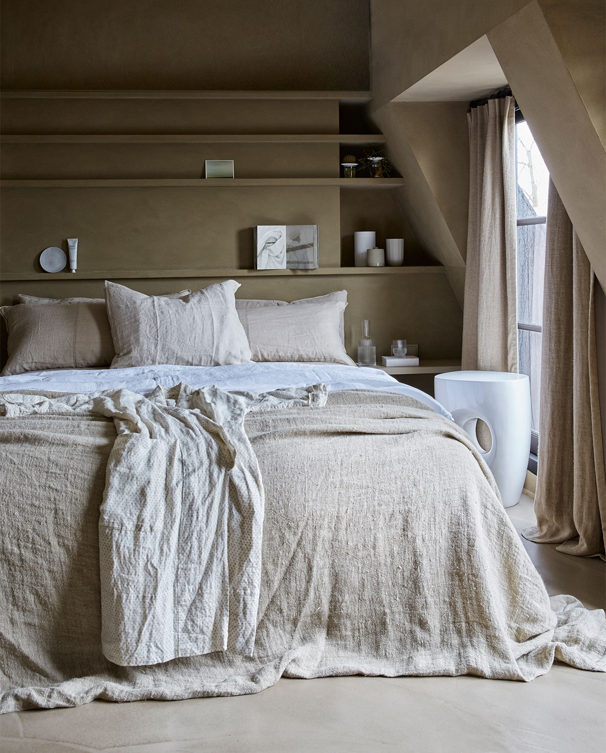 Muurverf Buffalo, prijs op aanvraag (Tribe). Vloer prijs op aanvraag (Pureconcept). Witte kruk, 35x40 cm (Øxh) € 251,- (Pols Potten). Bedsprei Natural, 270x270 cm € 229,- (HK Living). Linnen laken kleur Pure White, 160x255 cm € 119,-, voorste kussen kleur Flax, 60x70 cm € 30,- (By Mölle). Gordijnen kleur Stonewashed, prijs op aanvraag (Chivasso). Waterkan Ripple van Ferm Living € 34,-, glas Ripple van Ferm Living, set van 4 € 40,-, voetencrème van Meraki € 11,95, taupe vaas van D&M Depot € 9,95, paper vaas van Hay € 69,-, witte vaas van Menu € 54,95 (vtwonen.nl). Bord van Frédérick Gautier € 14,95 (Serax). Kaart vanaf € 0,90 (artlimited.net). Boek Out of Fashion (Birgitta de Vos). Plantjes (Sprout). Kimono (Sukha Amsterdam). Op maat gemaakte kast en kussens privébezit. vtwonen 08-2018 | styling Marianne Luning | fotografie Tjitske van Leeuwen | assistentie Emma Posma, Femke van Raaij