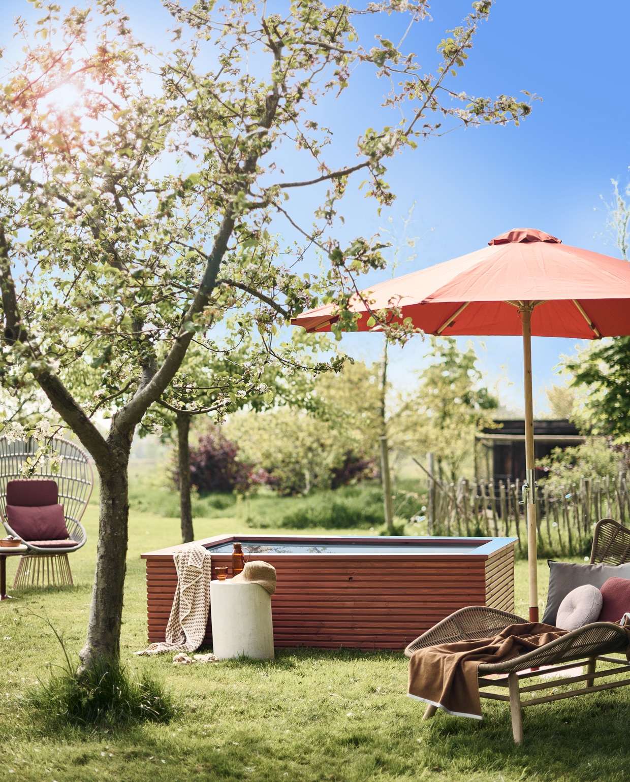 Ombouw zwembad DIY-project, geschilderd met Traditional Paint in kleur Dry Terra, per liter € 59,40 (pure-original.nl). Gepoedercoat aluminium fauteuil van Kettal € 3307,-, bijzettafel van B&B Italia, steen en staal, 44,5×40 cm (hxØ) € 1019,-, zachtroze rond buitenkussen vanaf € 410,- terra rechthoekig buitenkussen € 151,- (dacks.nl). Katoenen handdoek met gele print € 29,99, hoed € 22,99, bruine katoenen badhanddoek € 22,99 (zarahome.com). Microcementen kruk vanaf € 449,- (lanena-home.com). Waterglas € 5,99, karaf € 21,99 (sissy-boy.com). Parasol en parasolvoet, hout, staal en polyester, 260×300 cm (hxØ) € 219,- (lanterfant.eu). Ligbed van Kave Home, houten frame met polyester zitting, 169x84x91 cm (lxbxh) € 667,- (vtwonen.nl). Buitenkussen Padua van Designers Guild € 80,- (wva.nl).