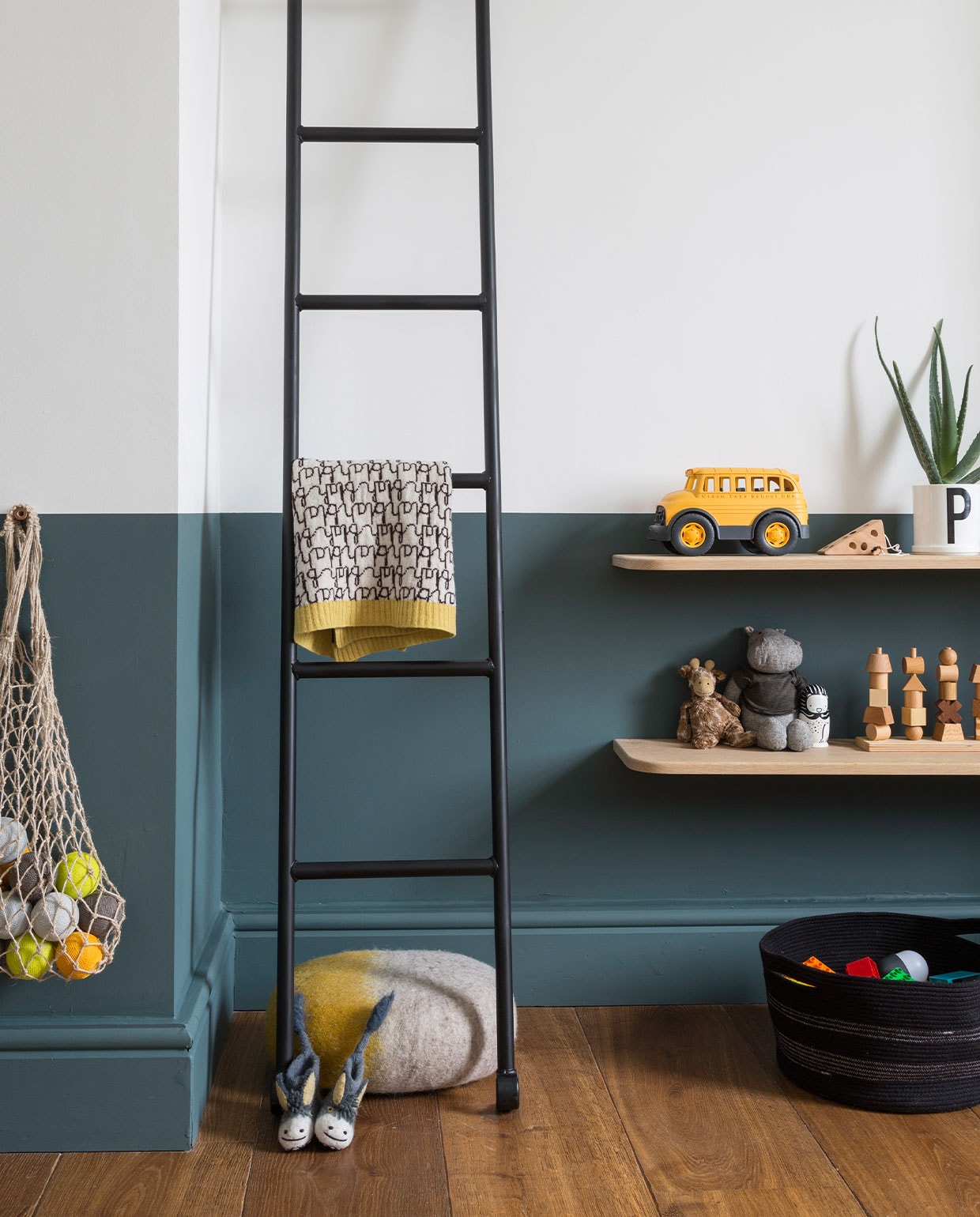 Ladder uit gymzaal, zelf zwart gespoten. Deken Donna Wilson, poef Muskhane. Sloffen Sew Heart Felt. Plantenpot met letter P Design Letters. Houten stapelspel Wooden Story. Overig onbekend. vtwonen 05-2022 | productie Living Inside | fotografie Kasia Fiszer