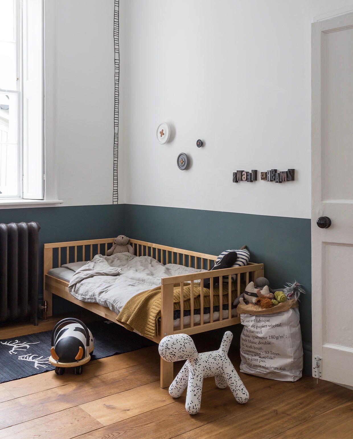 Muurverf lambrisering Estate Emulsion Inchyra Blue van Farrow &amp; Ball. Bed Ikea, dekbedovertrek Numero 74, vloerkleed Gur. Loopauto Wheelybug, puppykruk Magis. Papieren opbergzak Be-Poles/Saint-Lazare via Merci. Wandhaken HKliving. Overig onbekend. vtwonen 05-2022 | productie Living Inside | fotografie Kasia Fiszer