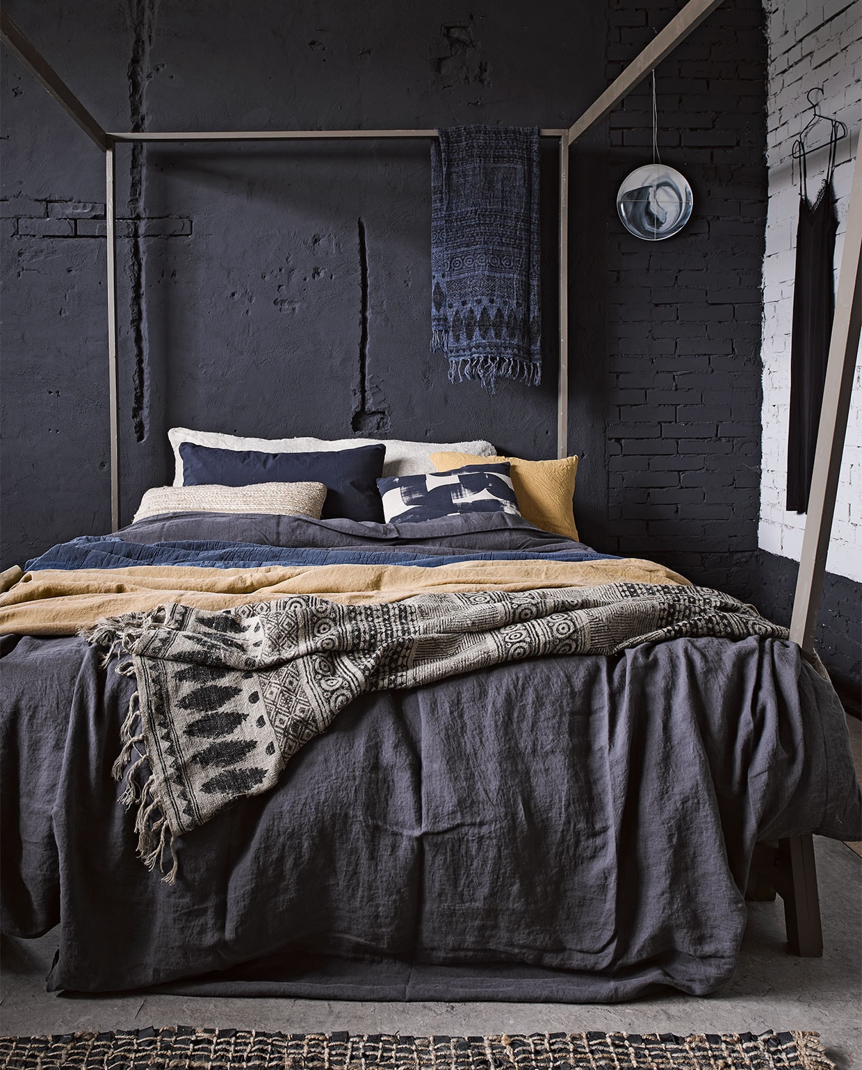 Hemelbed Safari, 160x200 cm € 375,- (Combitex). Linnen dekbedovertrek in offblack antraciet 240x220 cm € 149,95, kussen met gestempeld motief € 49,95 (Sissy-Boy). Donkerblauwe doorgestikte sprei vanaf 140x200 cm € 110,-, linnen doek met dessin in naturel en inktblauw 175x145 cm € 172,-, vloerkleed van geweven touw met leren stroken 90x150 cm € 95,-, alles van Madam Stoltz (Deens). Specerijengeel linnen laken van Society vanaf € XX, donkerblauwe katoenen kussenhoes van Society € 62,- (Meker Atelier). Kussen van geweven touw € 55,- (Nijhof). Kerriegeel linnen kussen 60x70 cm € 27,45 (Vandyck). Broodzak van vlas € 20,- (Combitex). Bord aan de muur € 85,- (Vij5). Jurkje (Just Female). vtwonen 03-2017 | styling Marianne Luning | fotografie Alexander van Berge